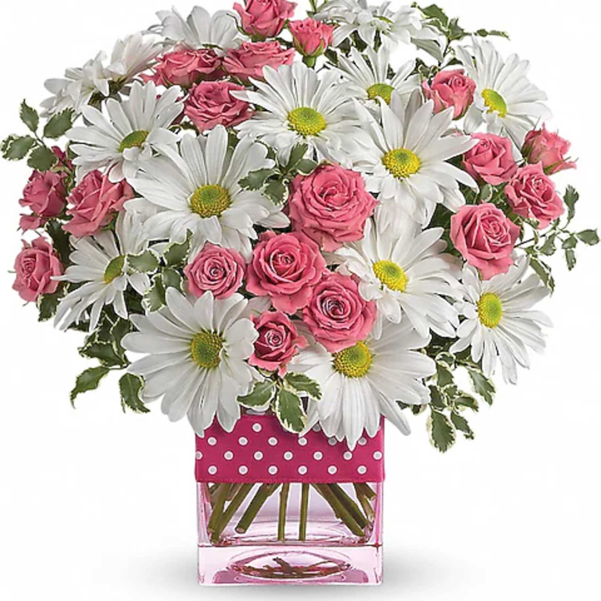Pink roses and white daisies in a clear square vase with a pink polka-dot wrap