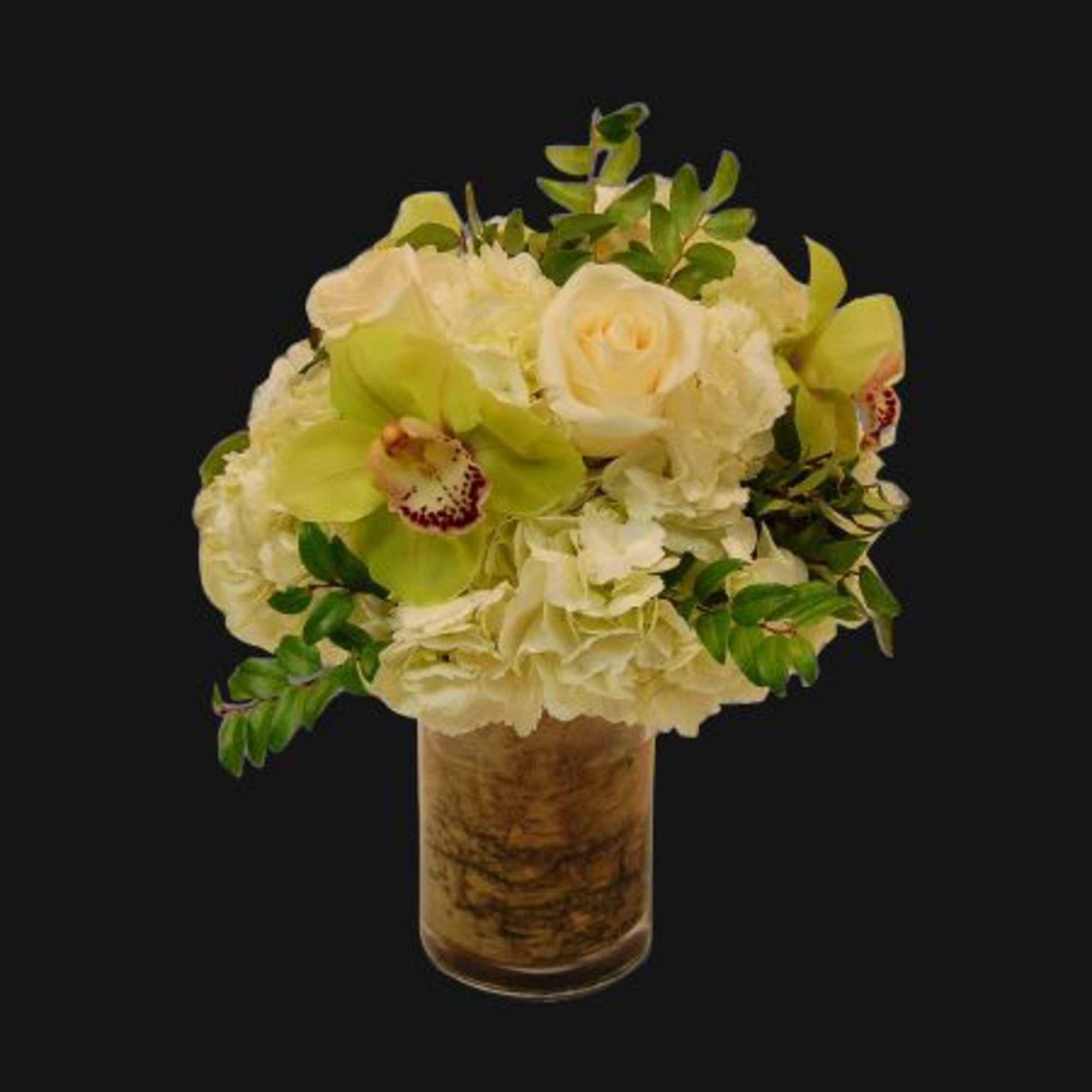 Cream and green floral arrangement in a tall glass vase