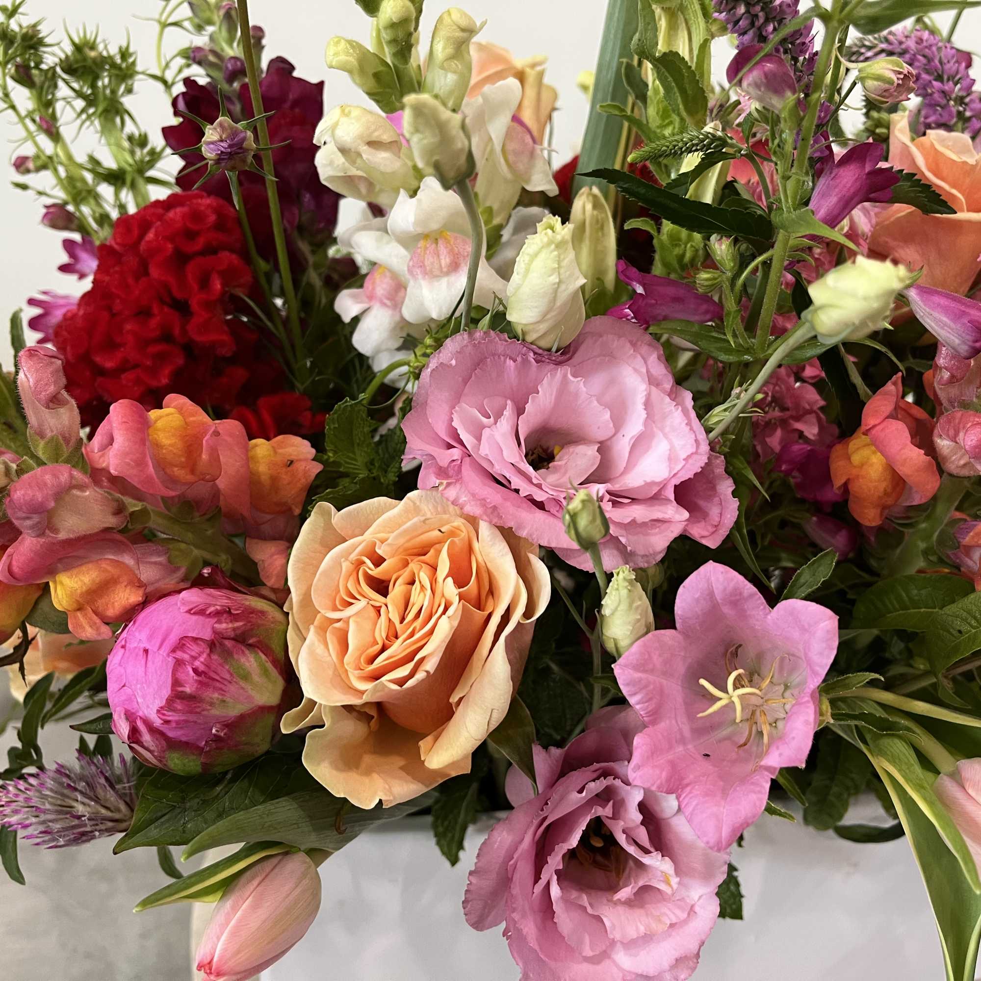 Mixed bouquet with pink, peach, red, and white flowers