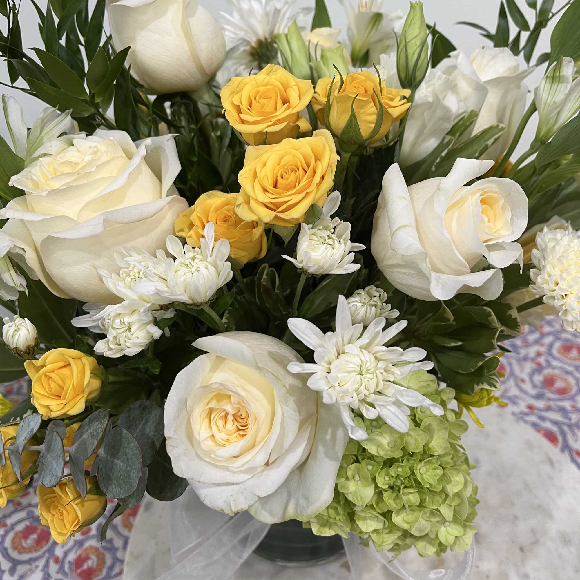 White and yellow roses with white daisies in a vase