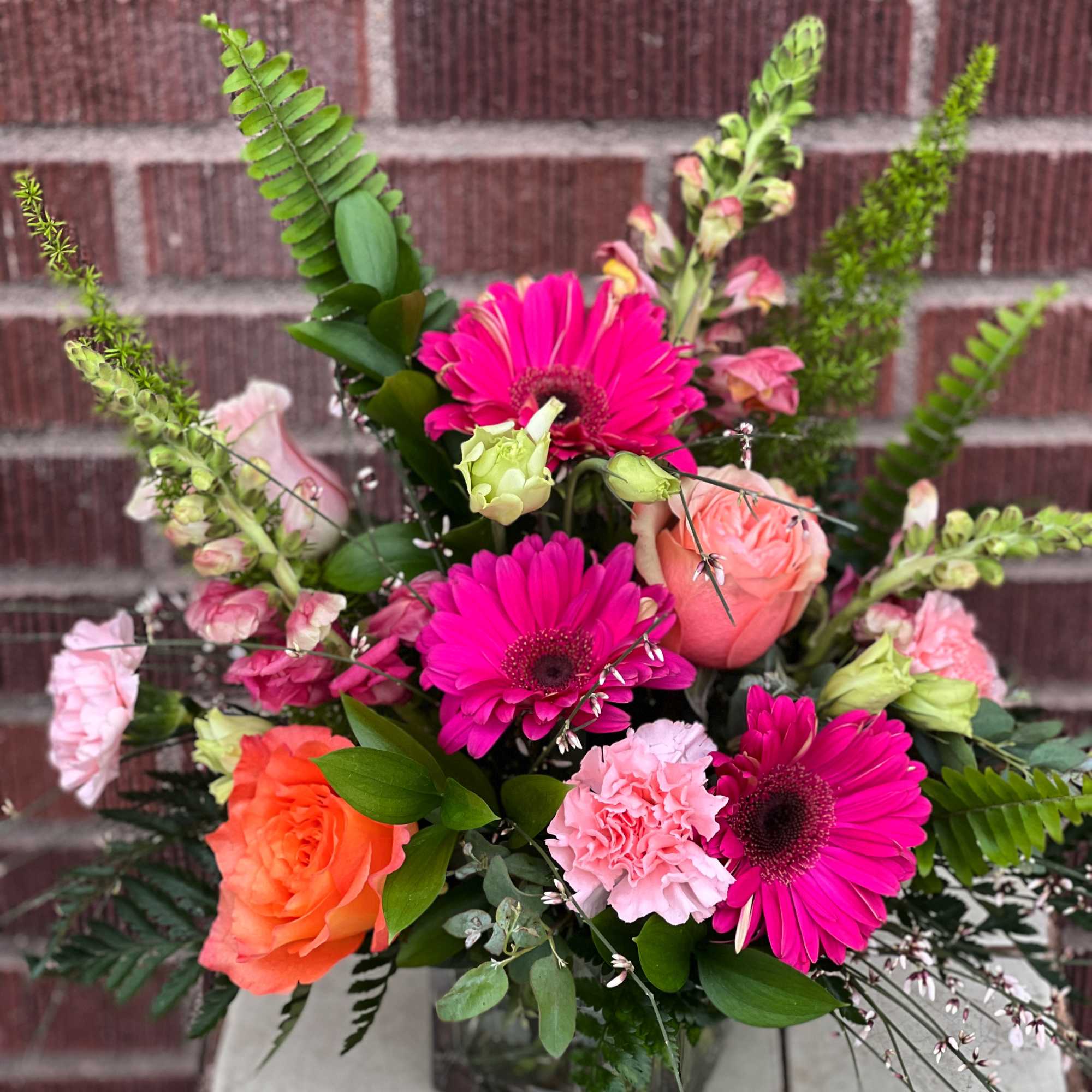 Pink and orange mixed bouquet with gerbera daisies, roses, and carnations