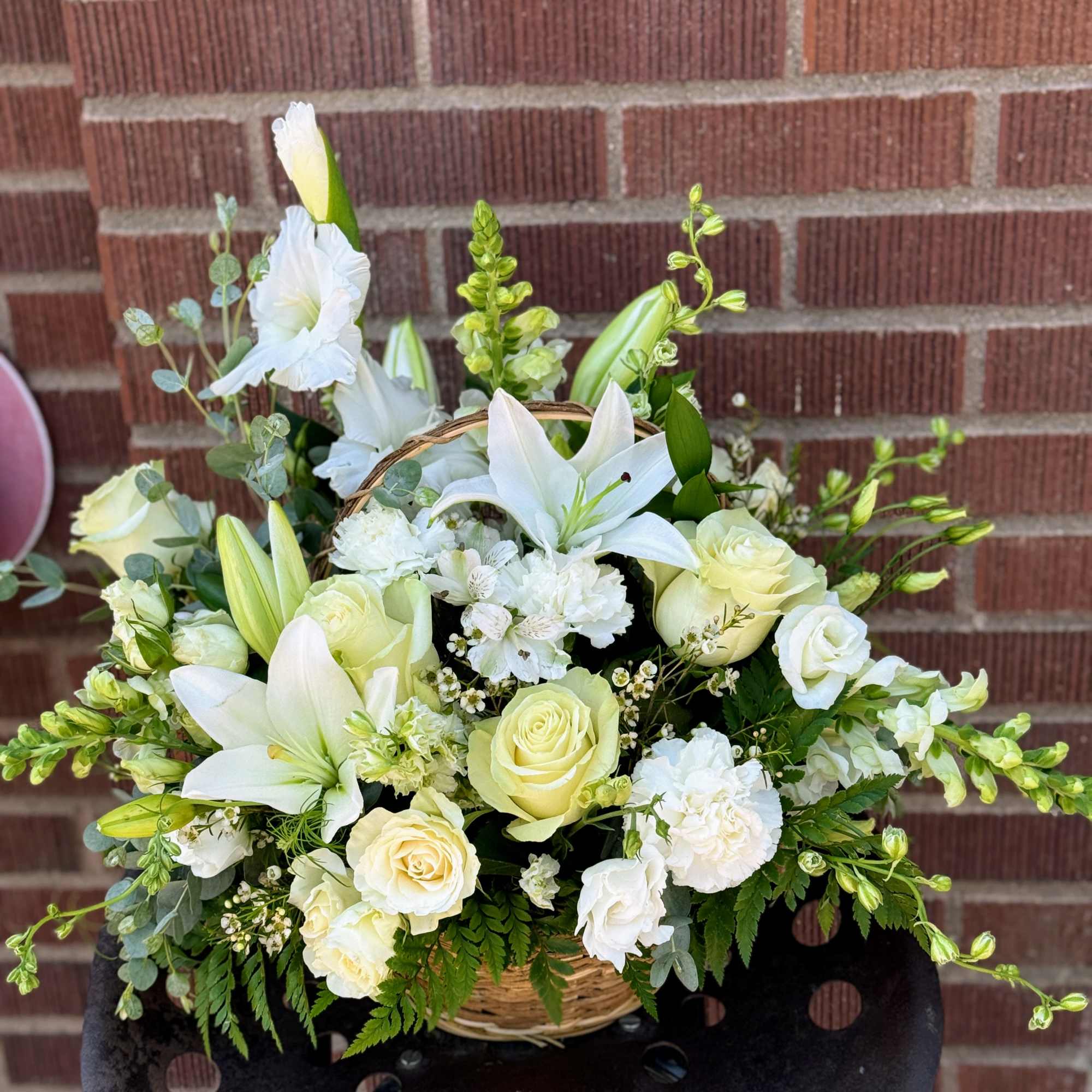 White and pale yellow floral basket arrangement with lilies and roses