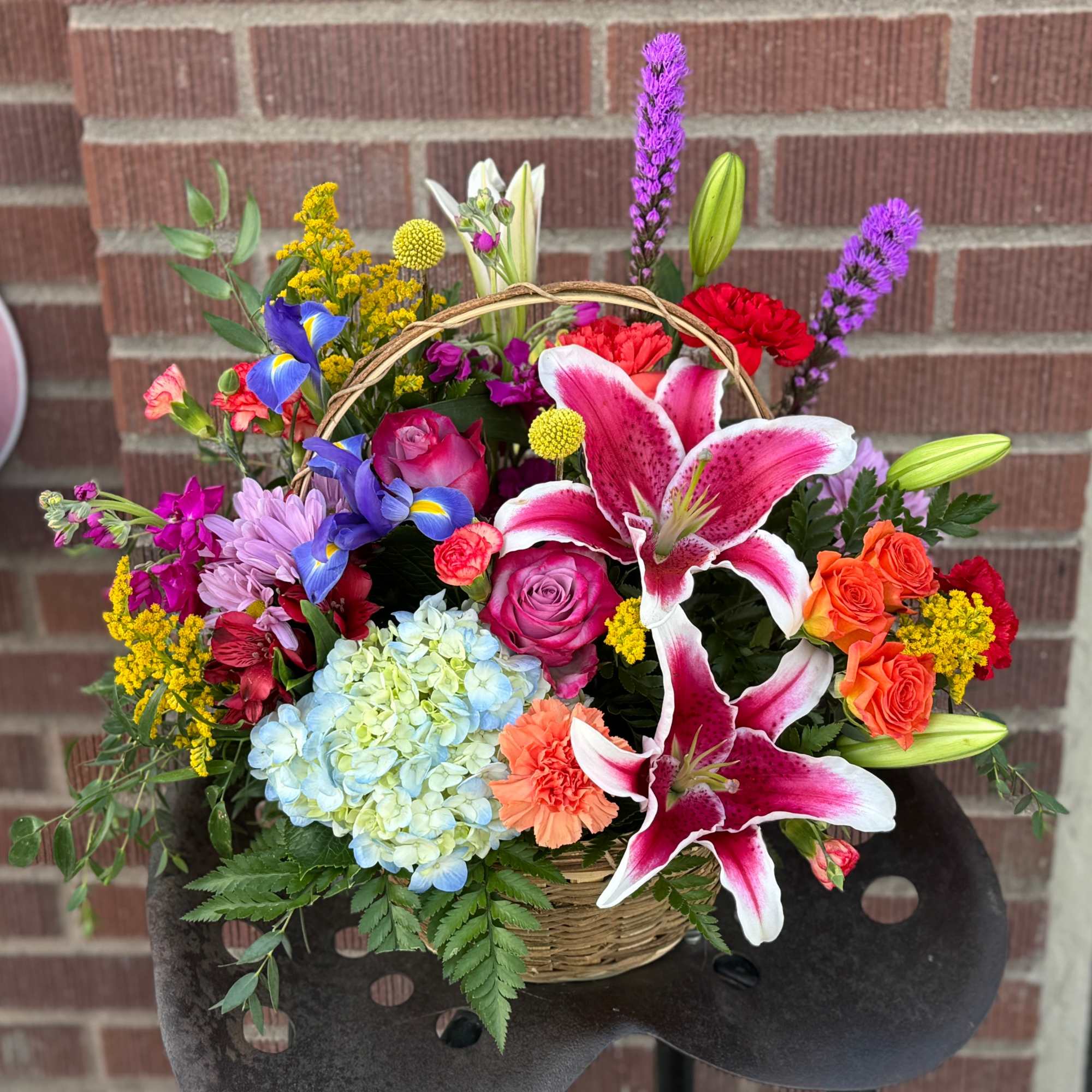 Colorful mixed flower basket with lilies, roses, hydrangea, and carnations