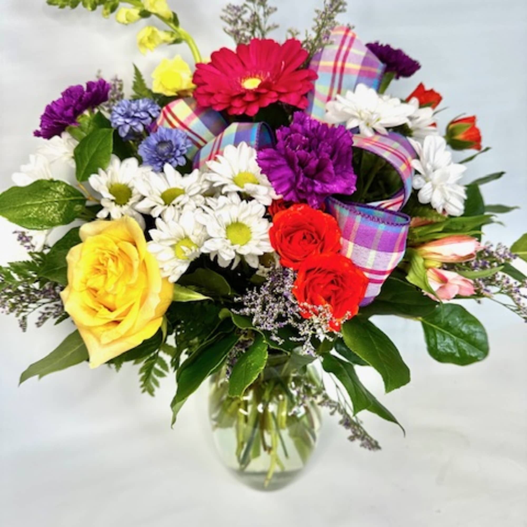 Fresh bright mixed blooms arranged in a clear container., photo 2 of 2