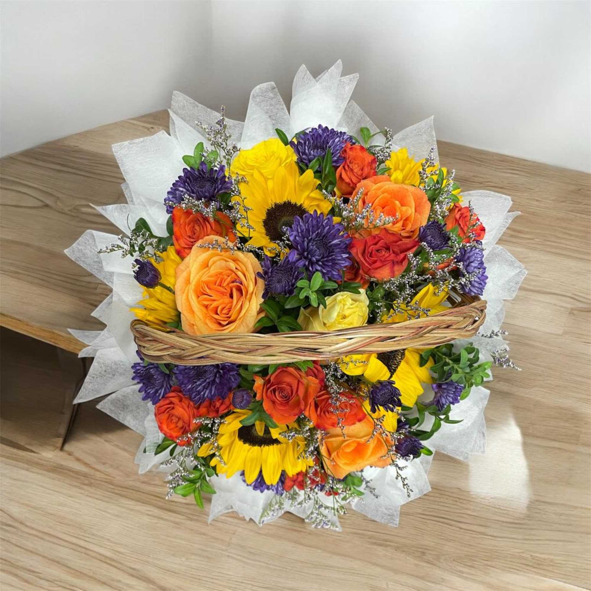 Basket bouquet of sunflowers, roses, and purple mums