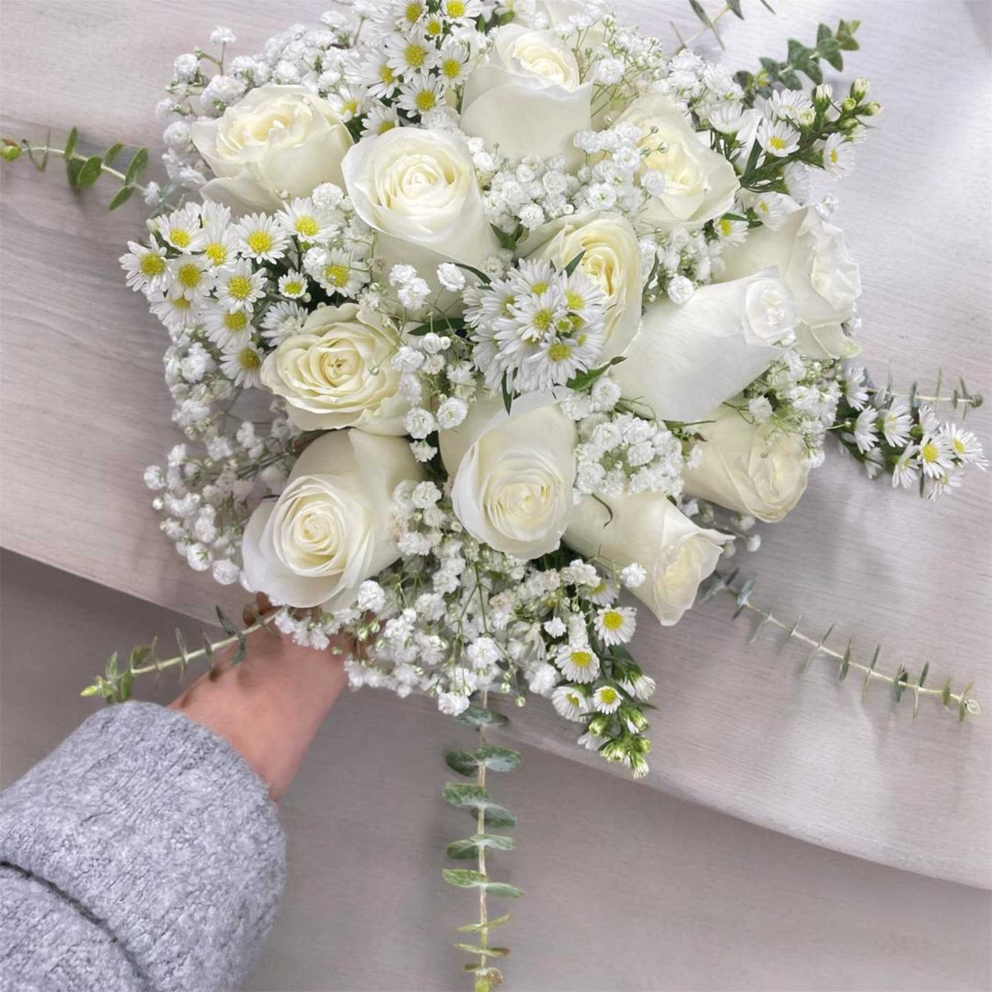 White rose bouquet with small daisy-like flowers and baby's breath