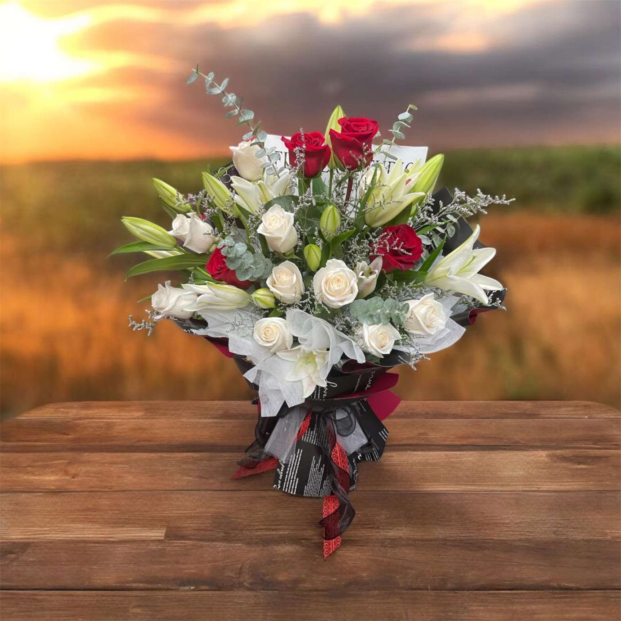 Bouquet of red and white roses with lilies and ribbon wrap