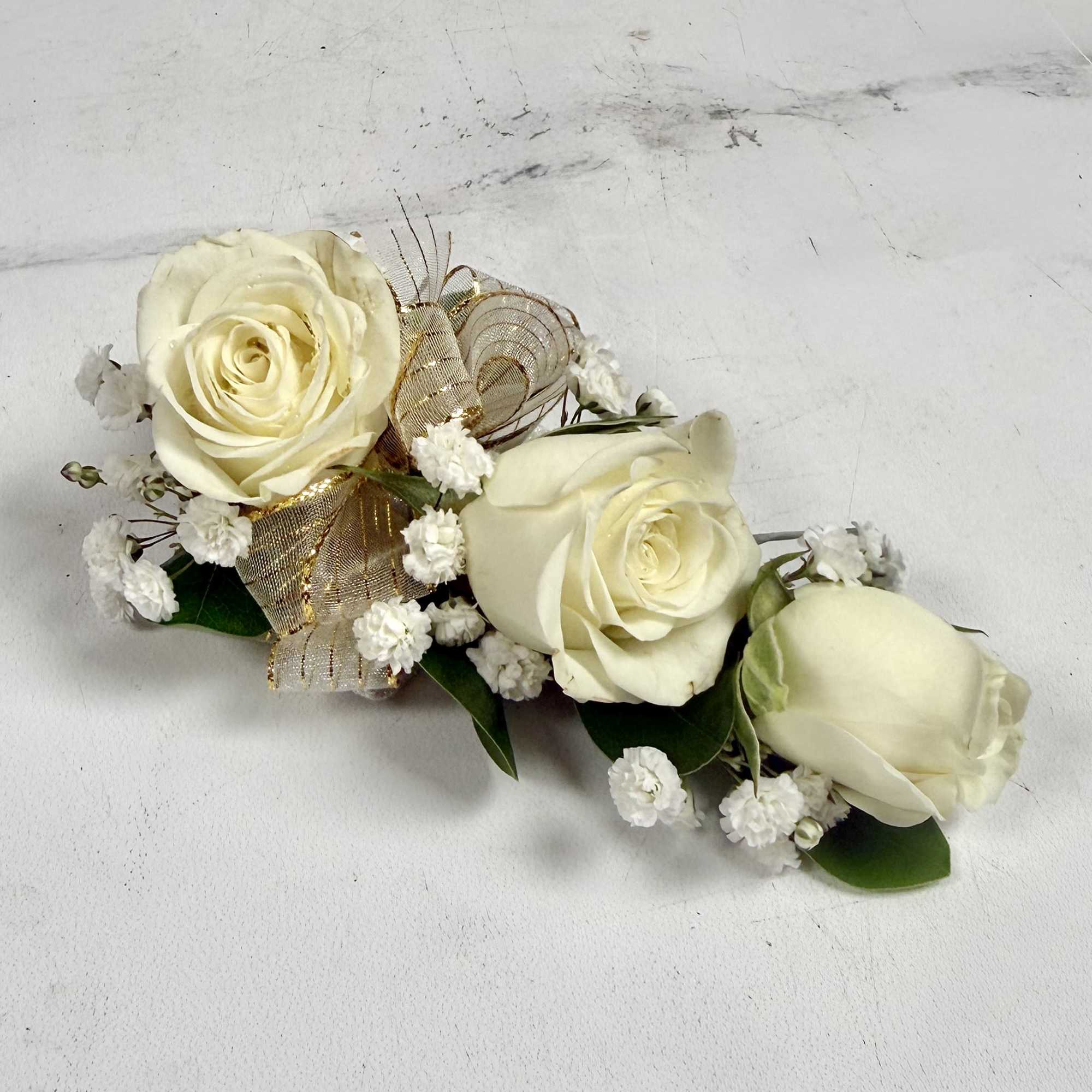 This wrist corsage features three white spray roses, babies breath and white, photo 2 of 3
