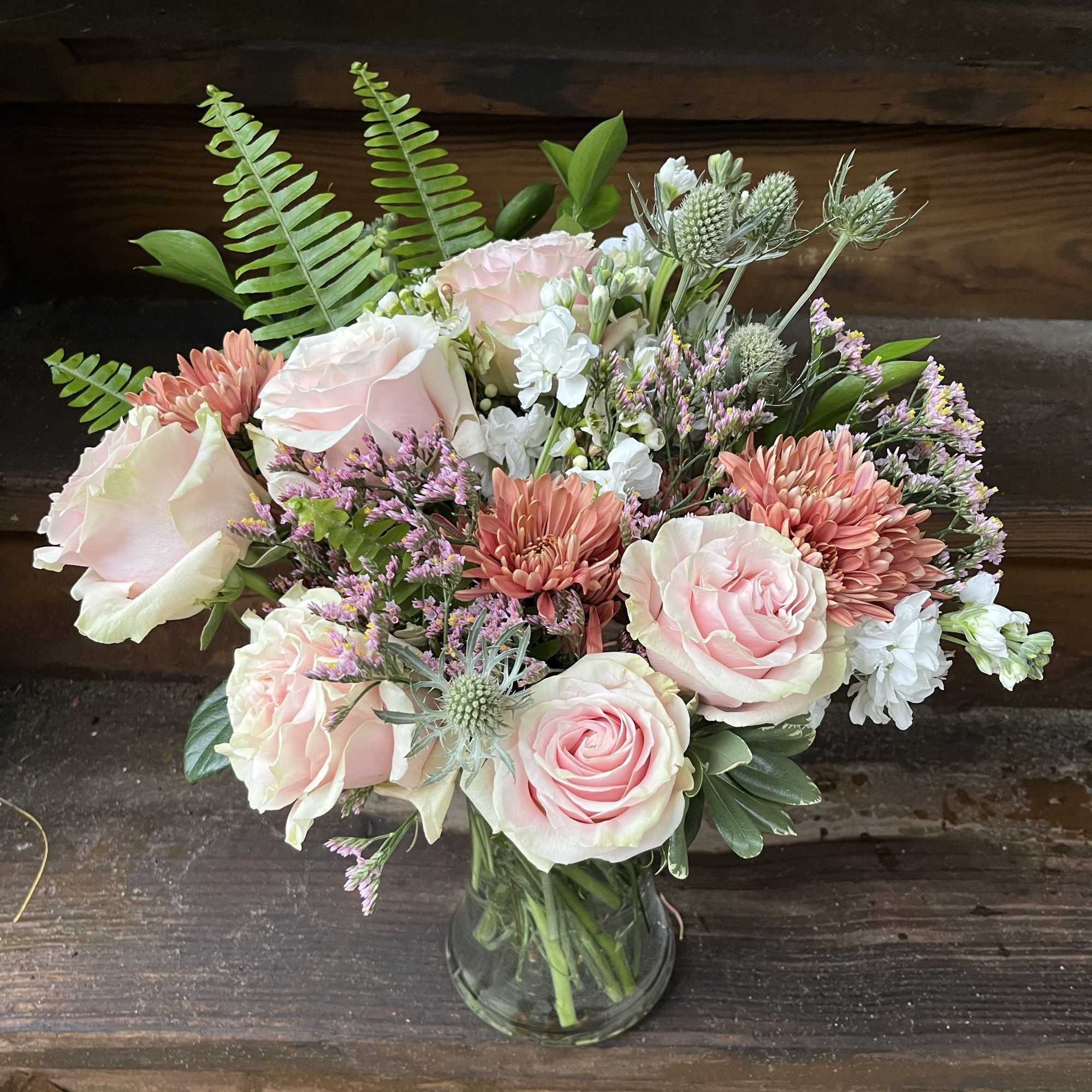 Pink roses and peach chrysanthemums in a glass vase