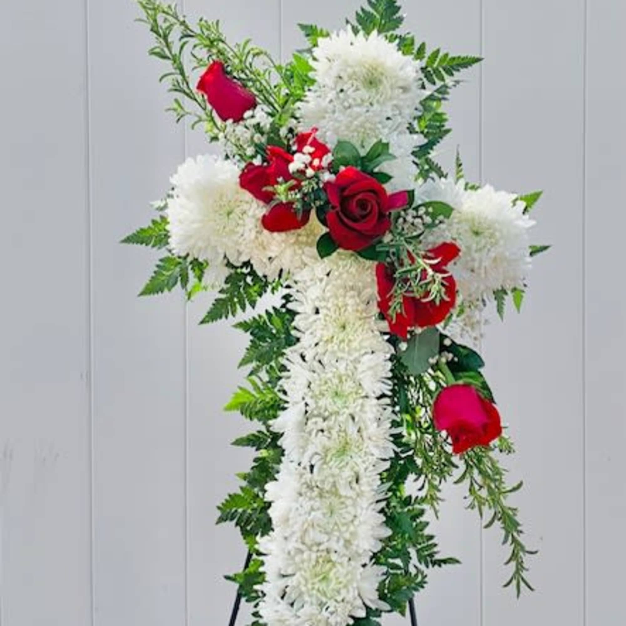 Standing floral cross with white flowers and red roses