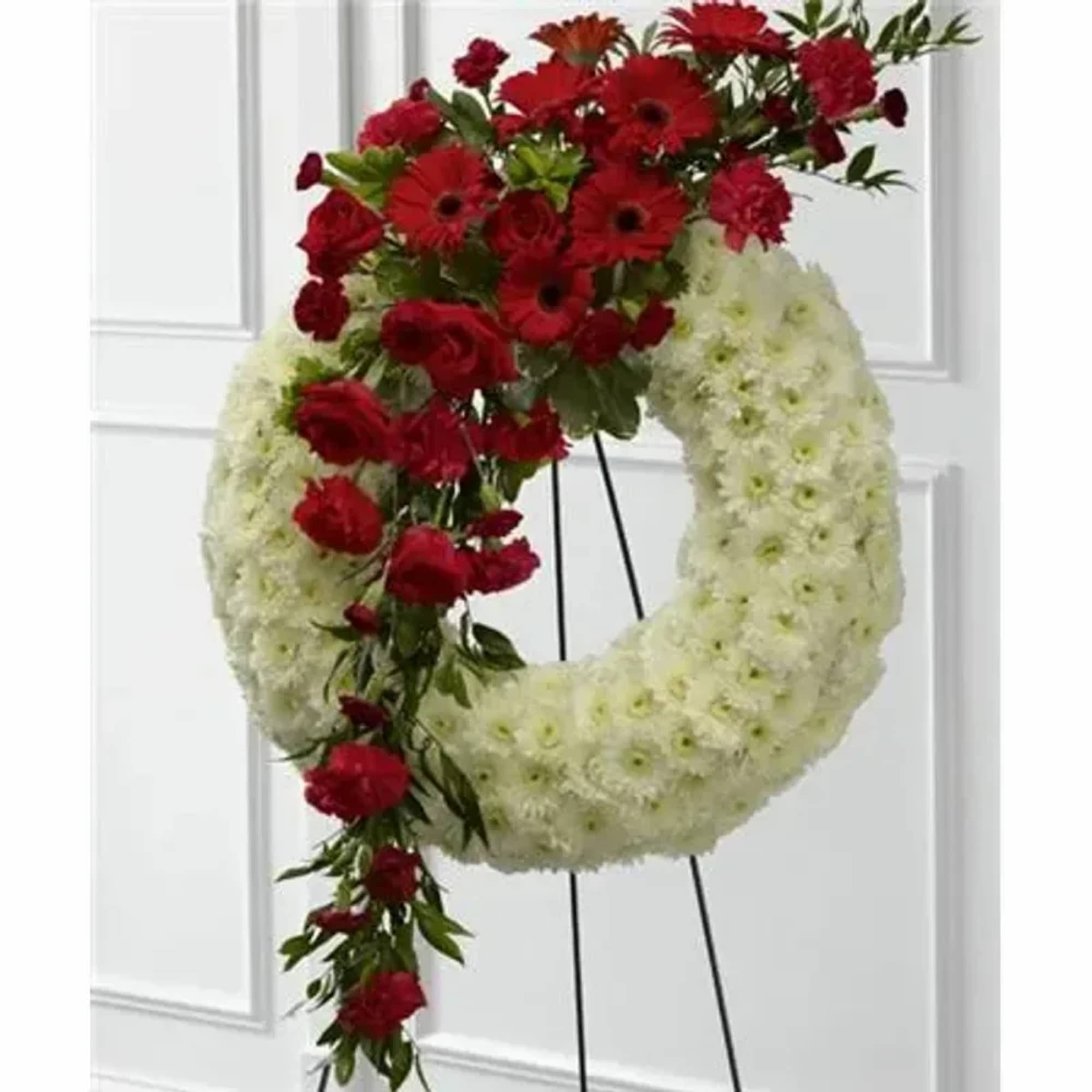 Red roses, carnations and gerbera daisies are accented with burgundy mini carnations