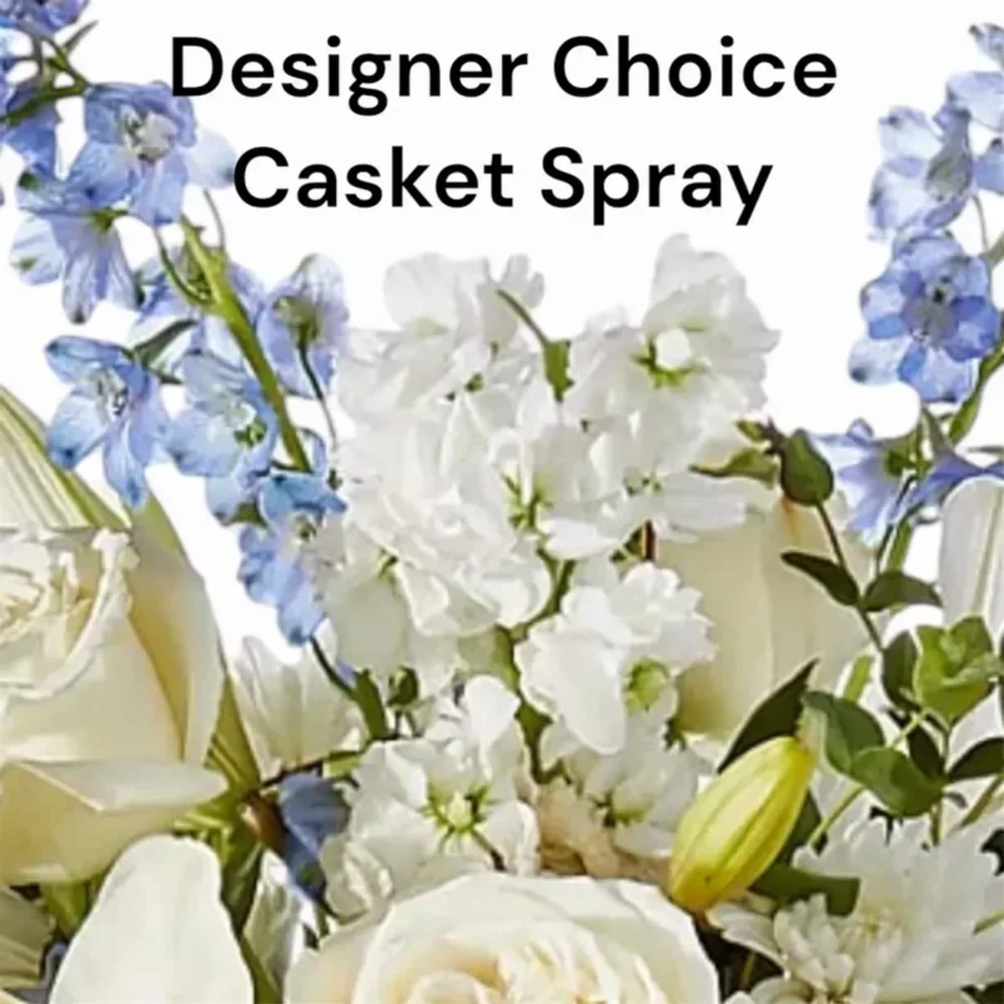 A serene, elongated casket spray arranged in white, blue and green that