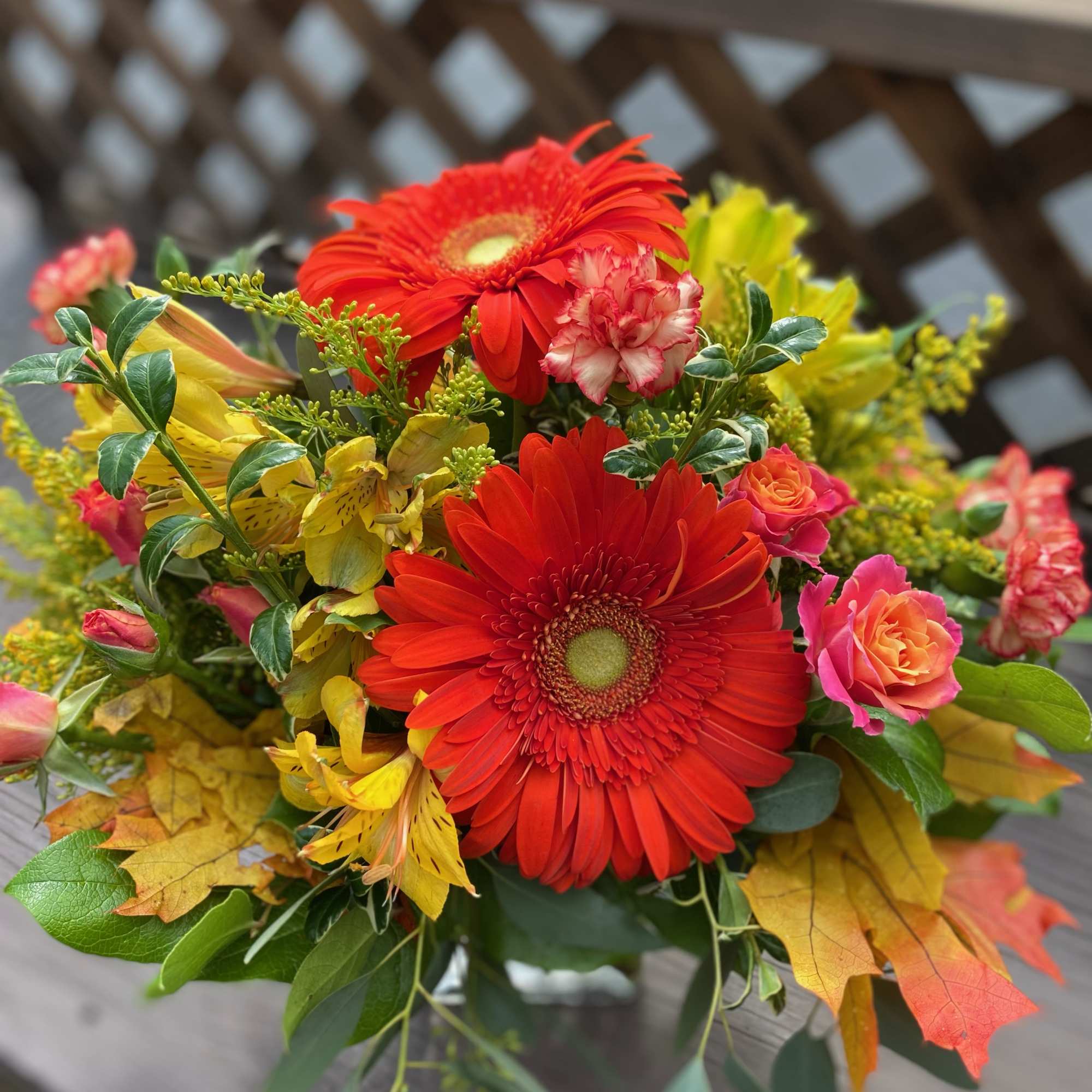 Bouquet of red gerbera daisies and yellow flowers with pink roses