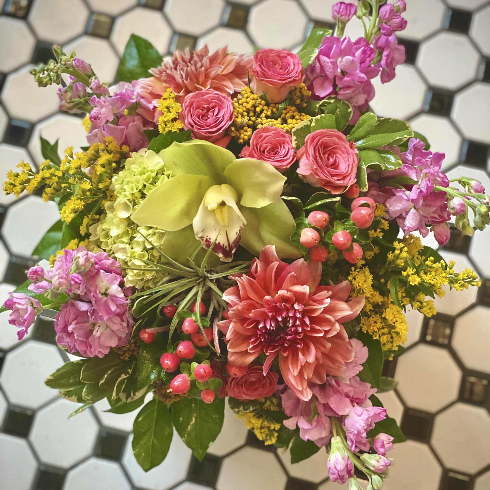 Mixed bouquet with pink roses, orchids, and a green orchid bloom