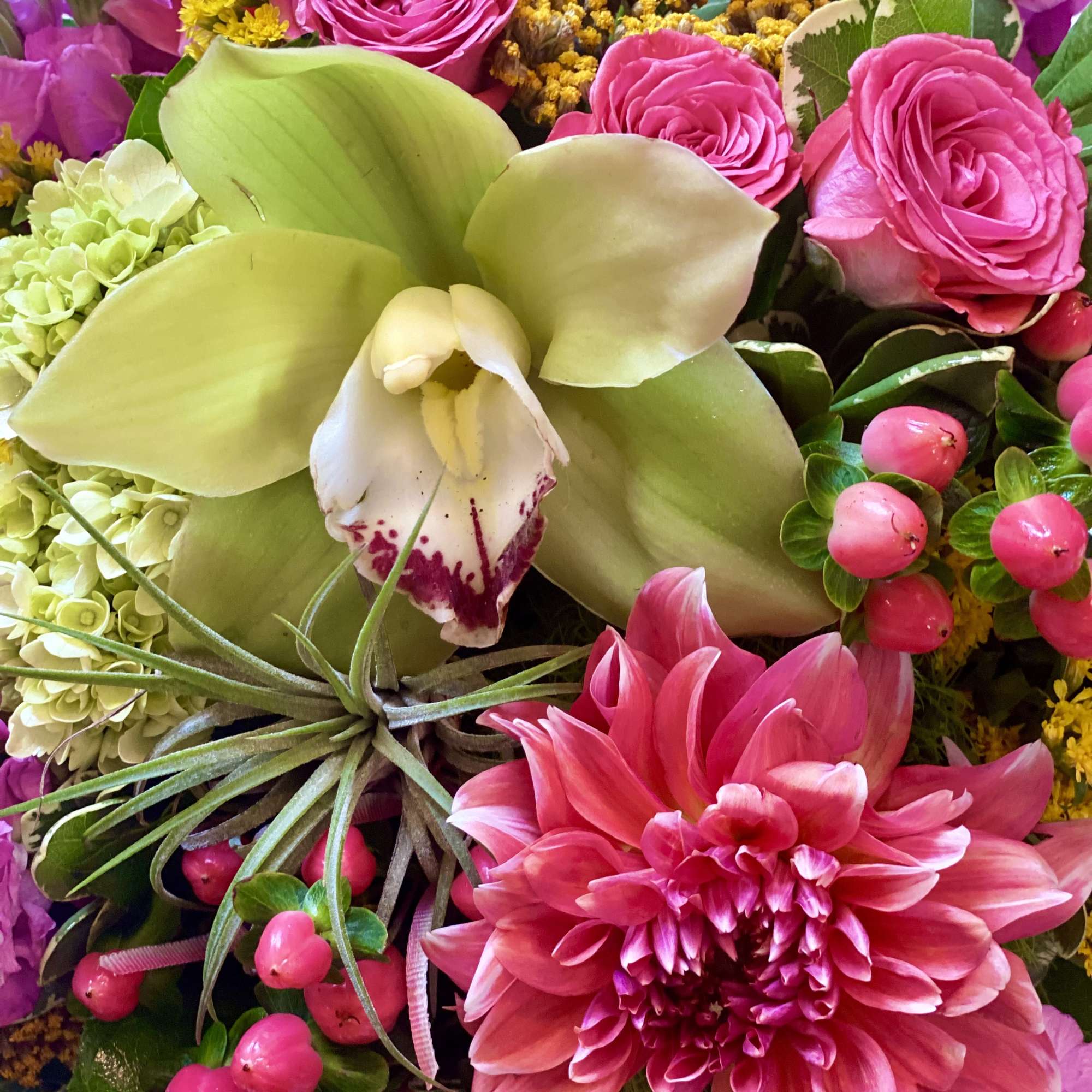 Pink roses and a large orchid bloom with a bright dahlia