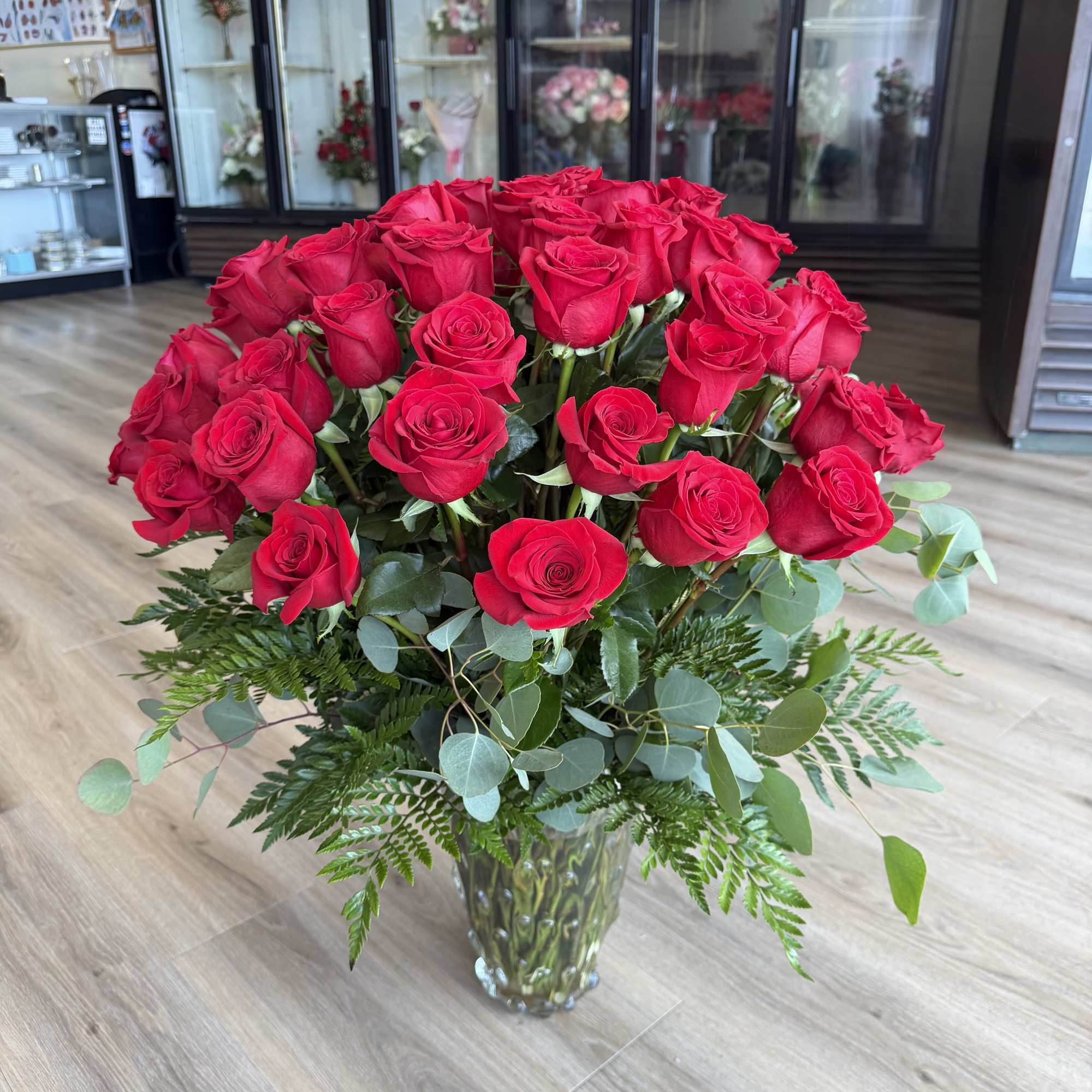 A lush 60ct dome of vivid red roses creates an immediate romantic