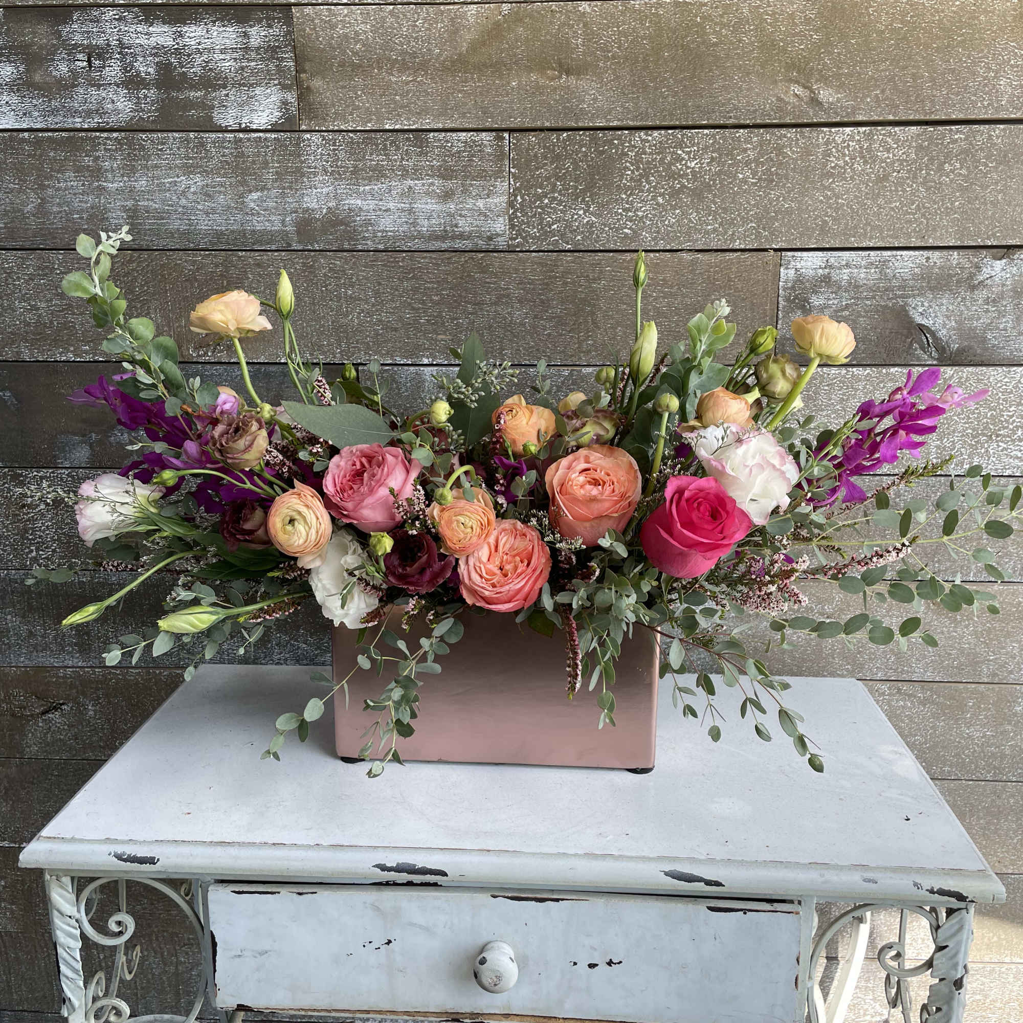 Mixed pink and peach floral arrangement in a blush rectangular box