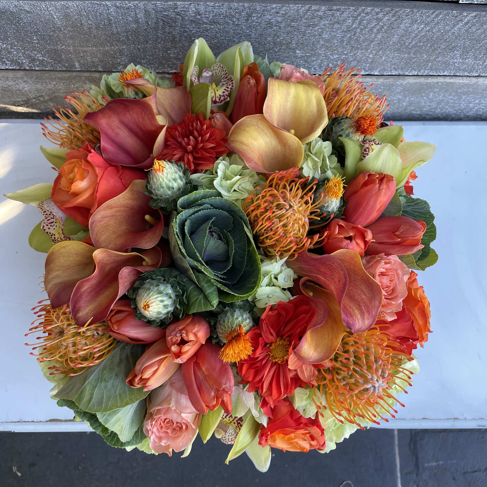 Mixed bouquet with calla lilies, roses, and orange pincushion blooms