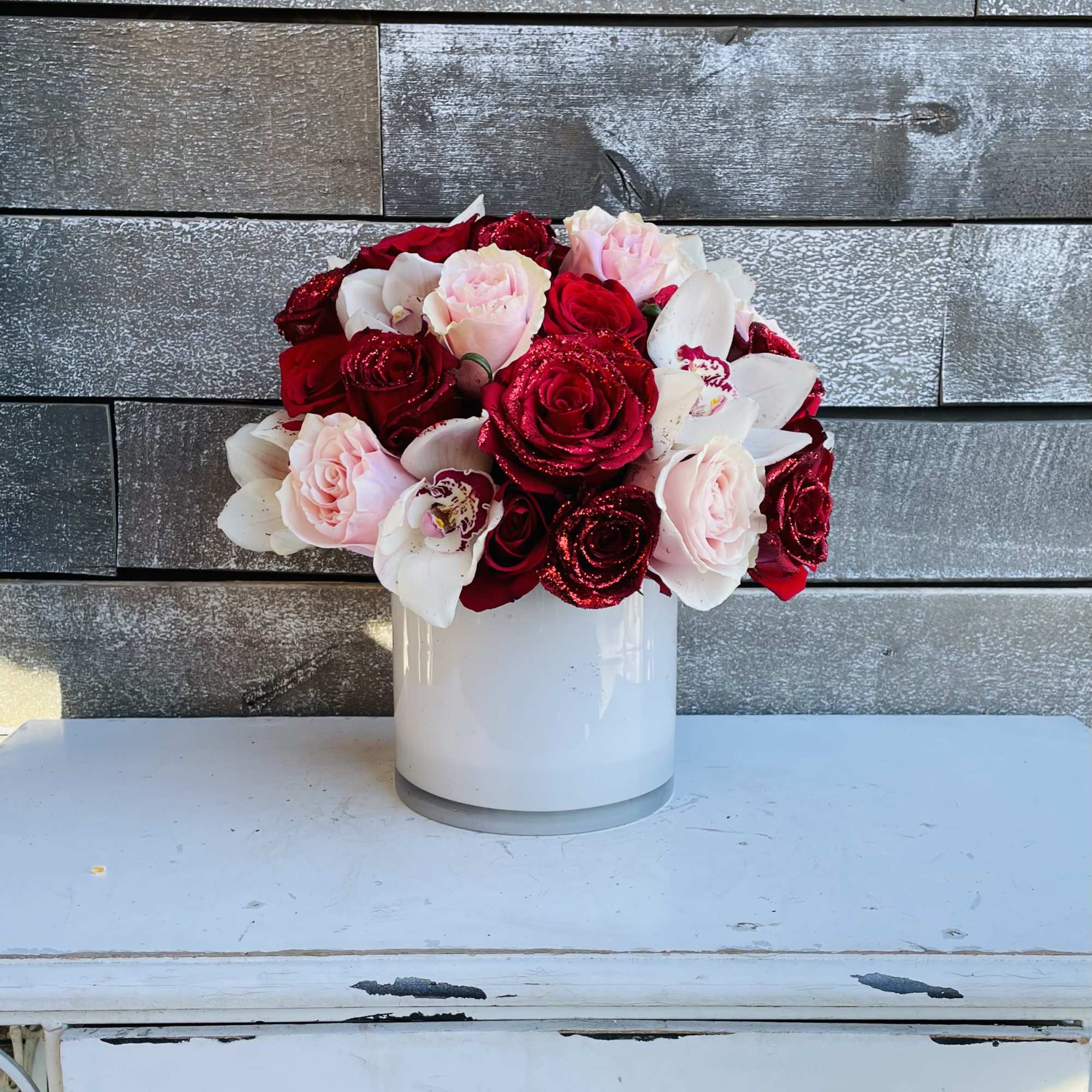 Bouquet of red and pink roses in a white vase