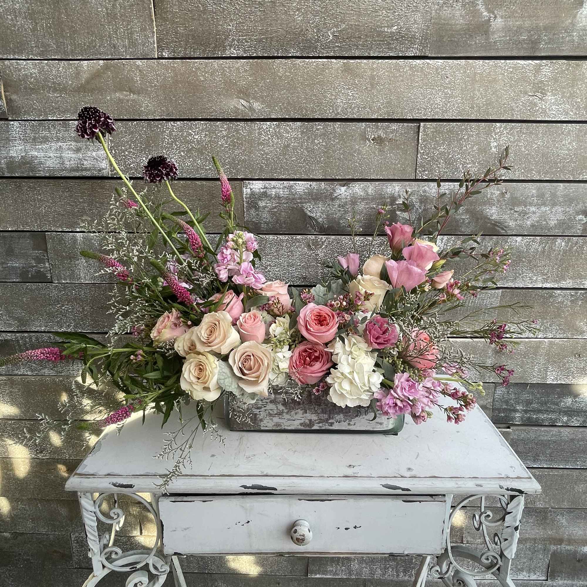 Pink and cream rose arrangement in a rectangular container