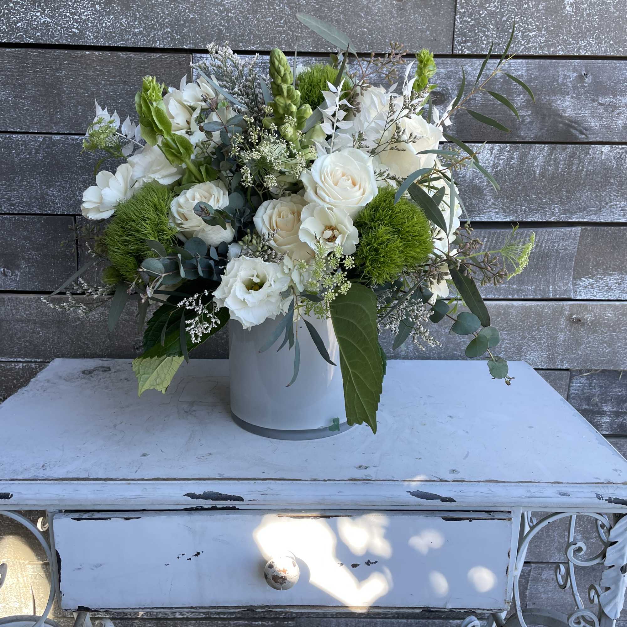 White floral arrangement in a pale vase with green accents, photo 4 of 5