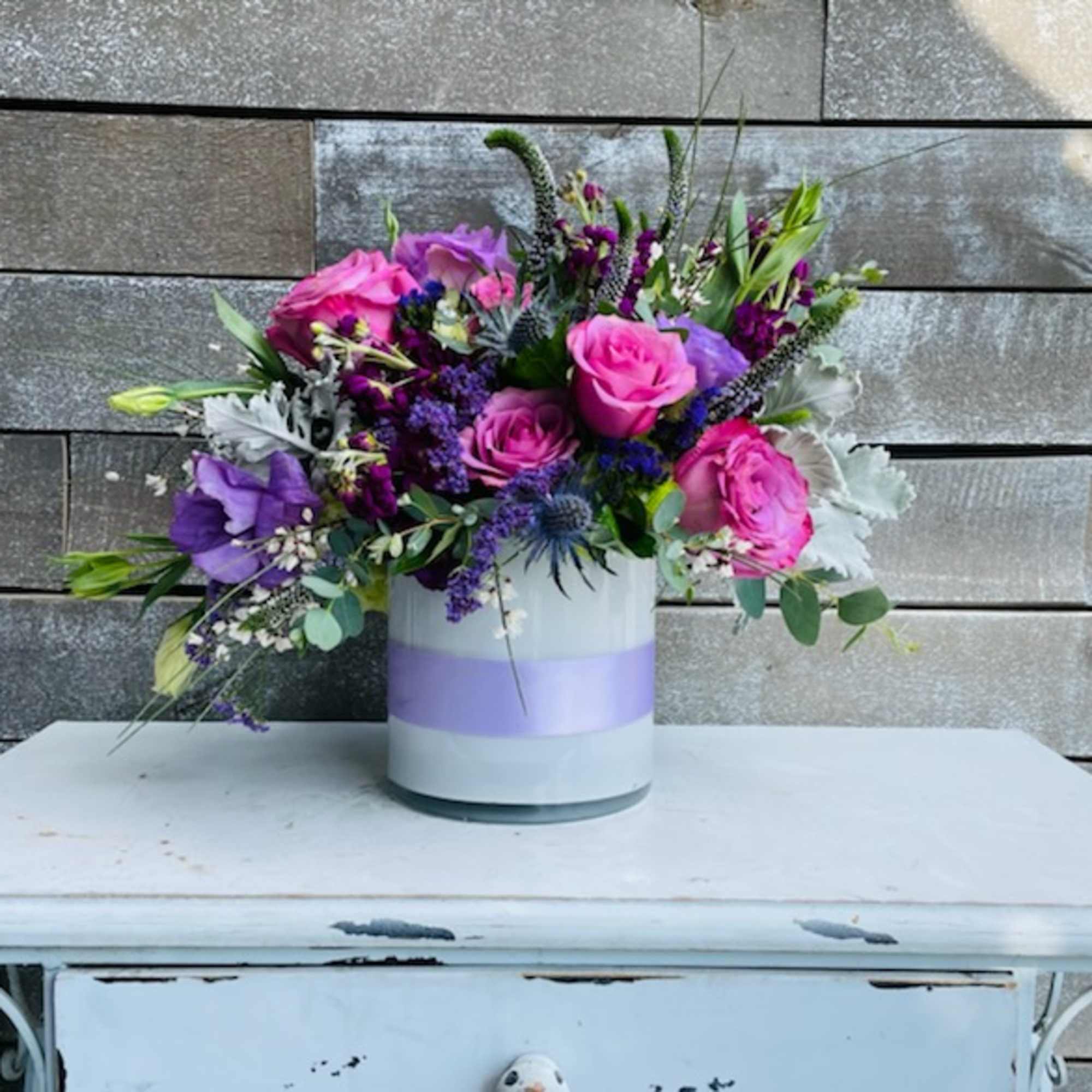 Bouquet of pink and purple flowers in a white vase
