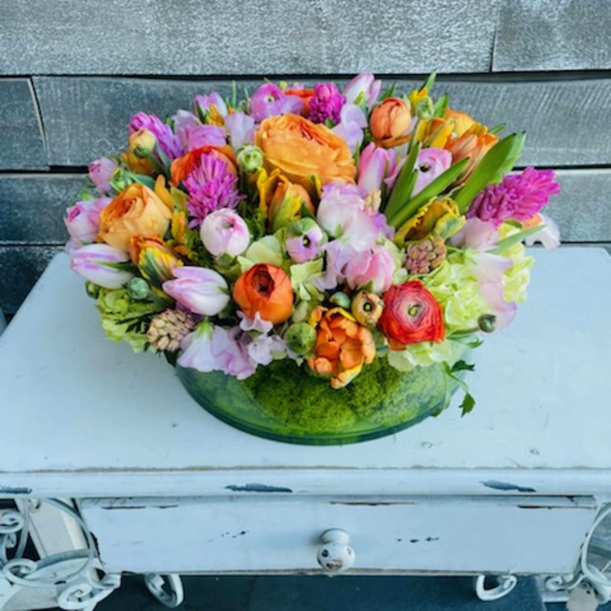 Colorful mixed bouquet in a low green glass bowl