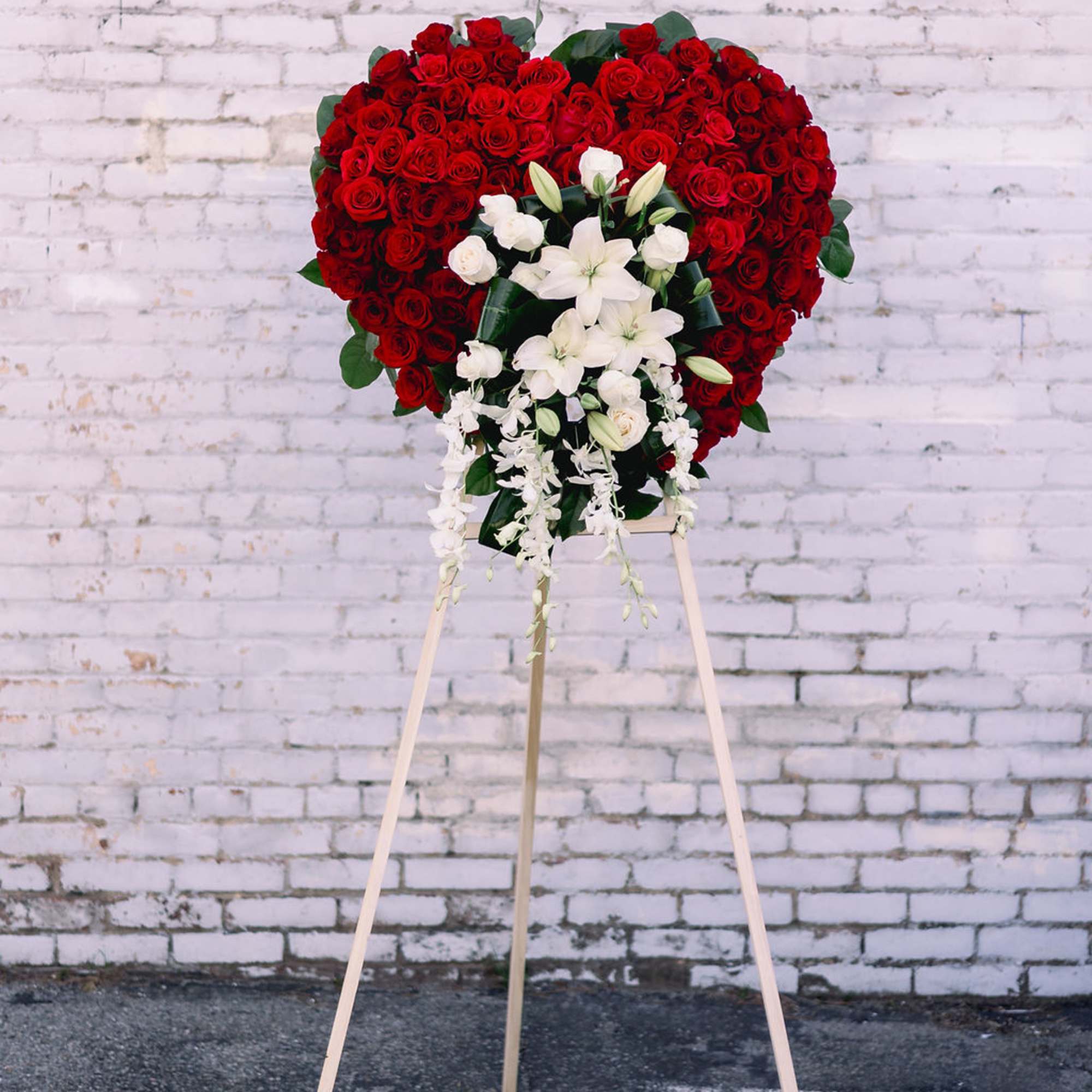 Heart-shaped red rose standing spray with white lilies on an easel