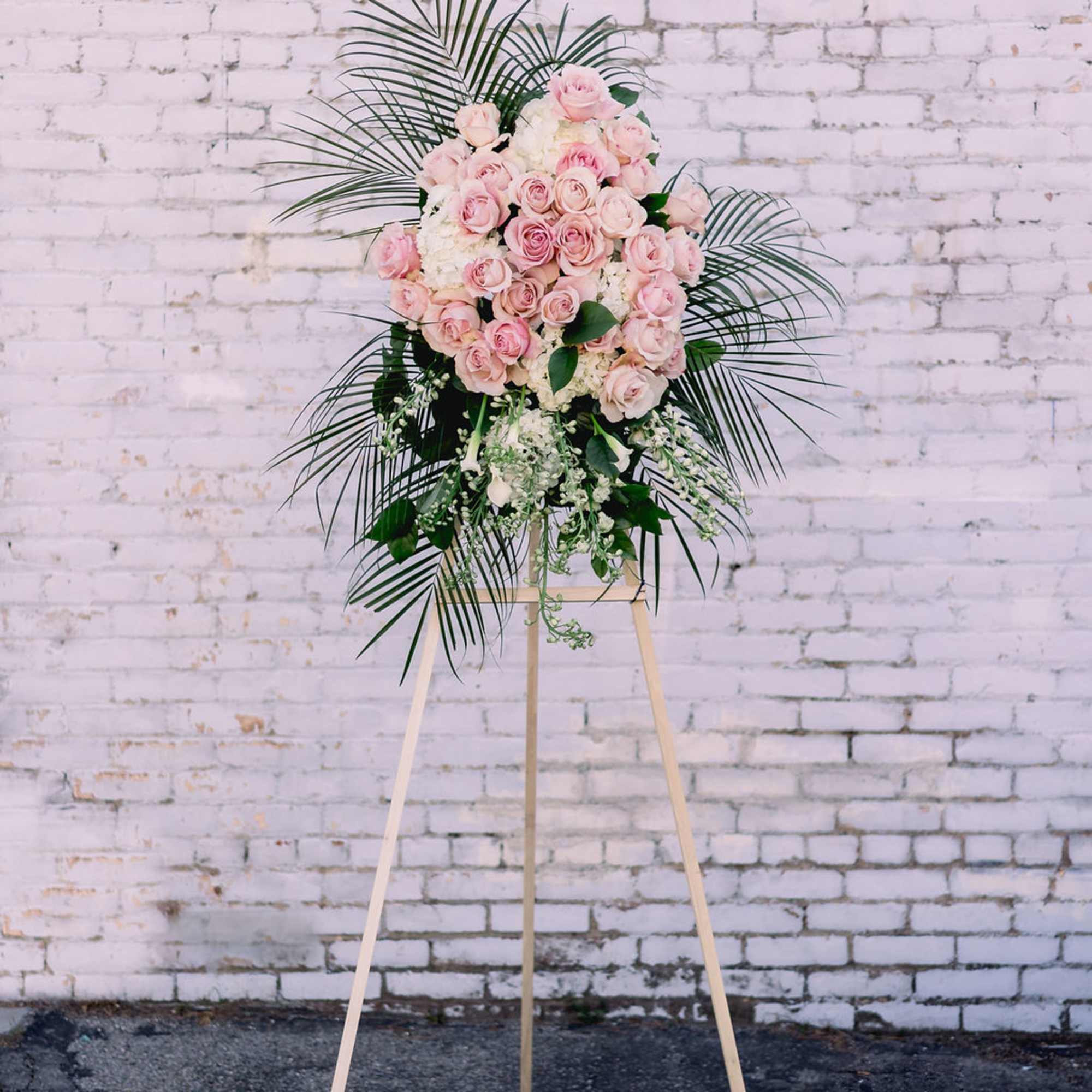 Pink rose floral spray on a wooden easel