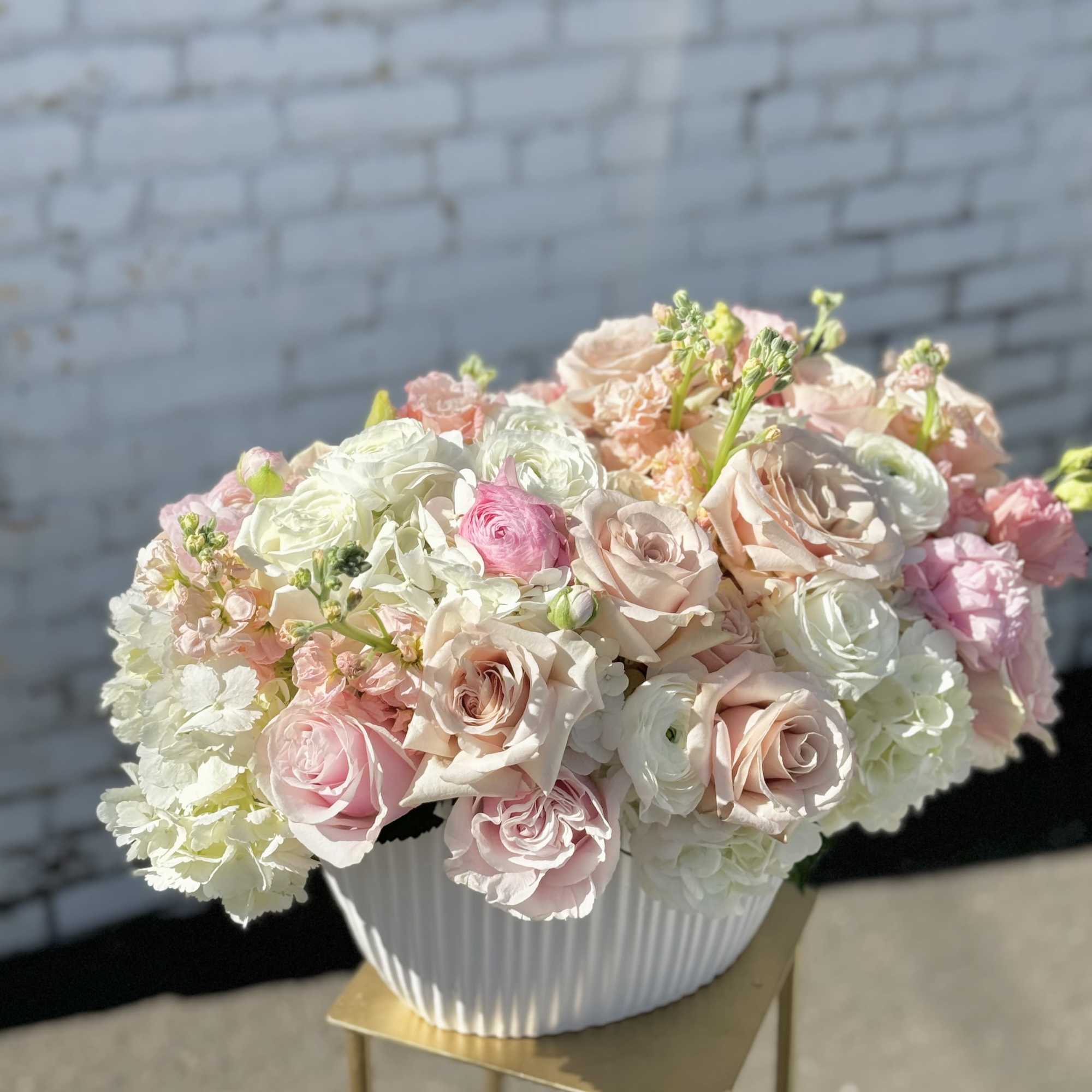 Pastel pink and white rose bouquet in a white vase