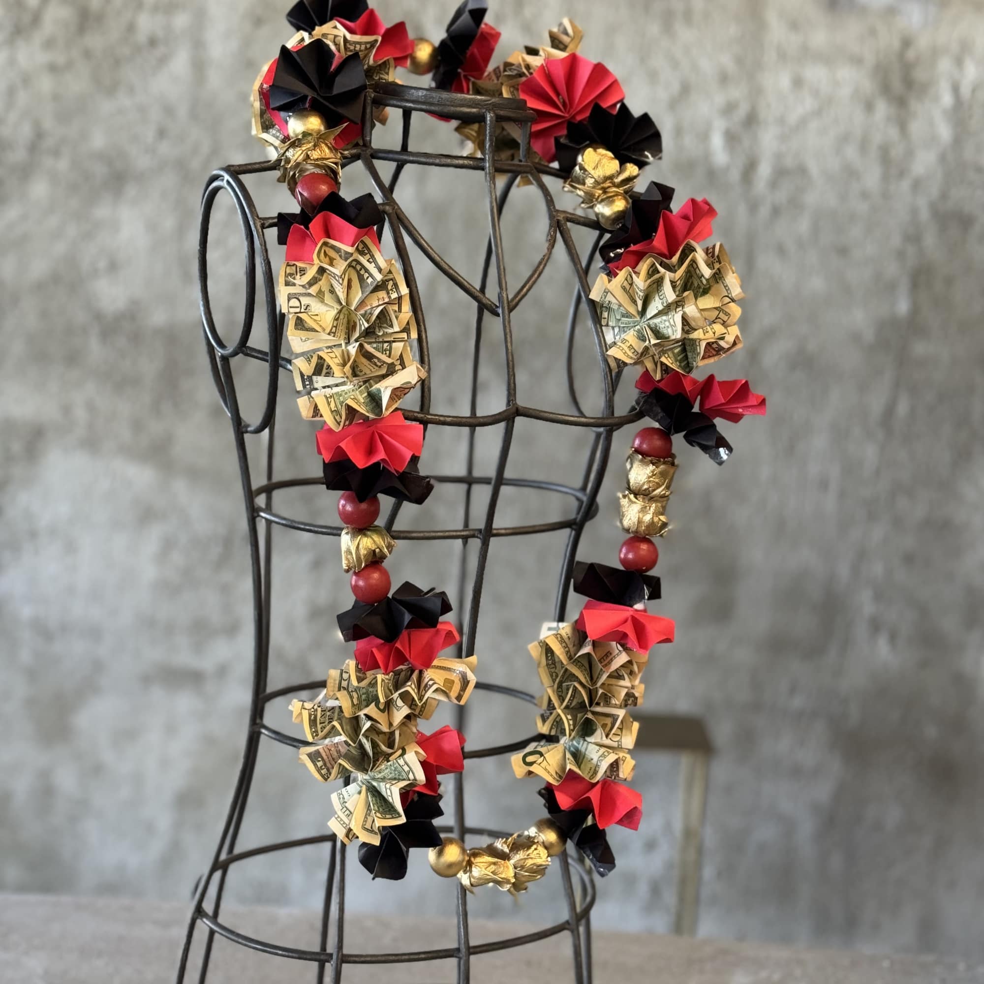 Money lei draped over a wire dress form, photo 4 of 5
