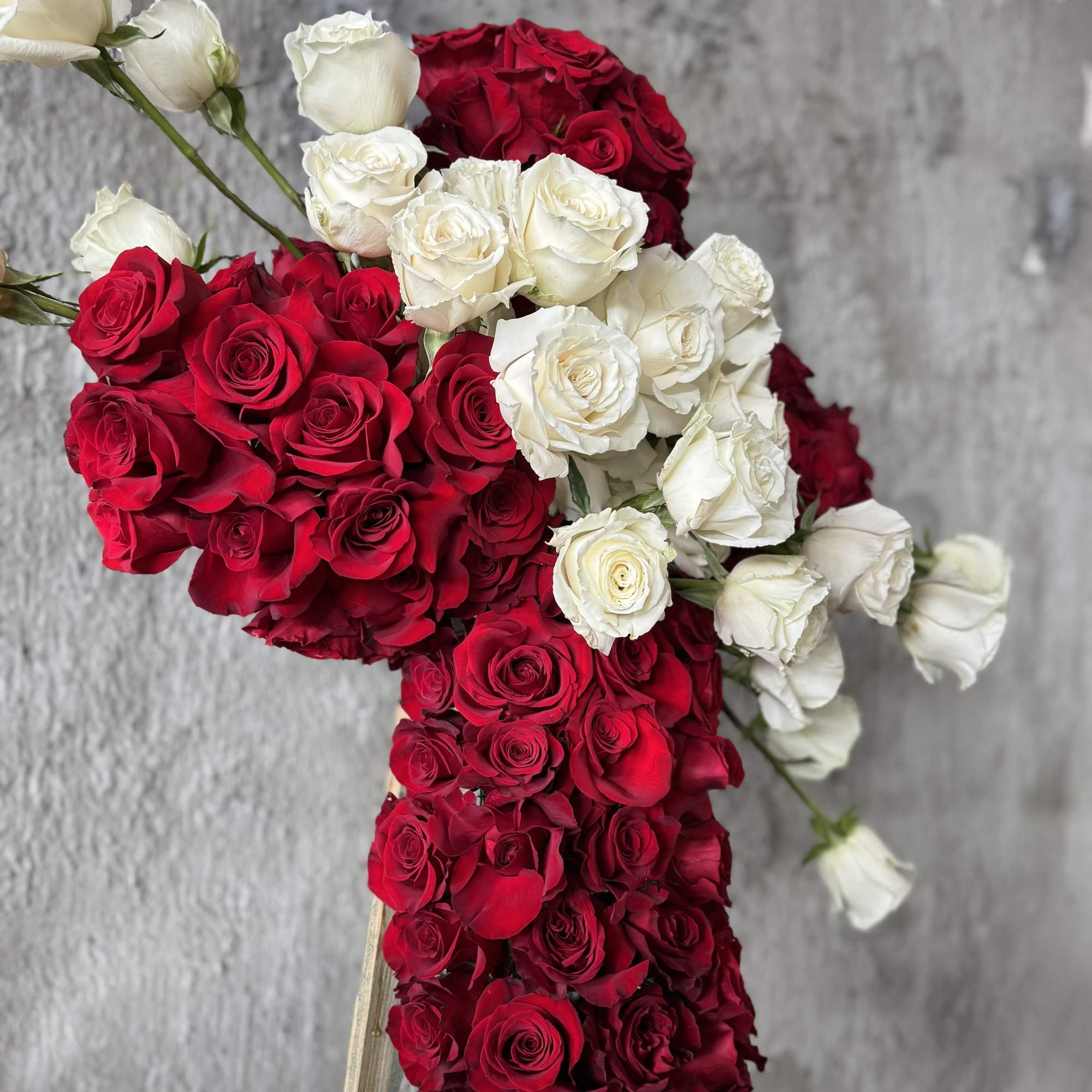Red and white rose arrangement on a stand