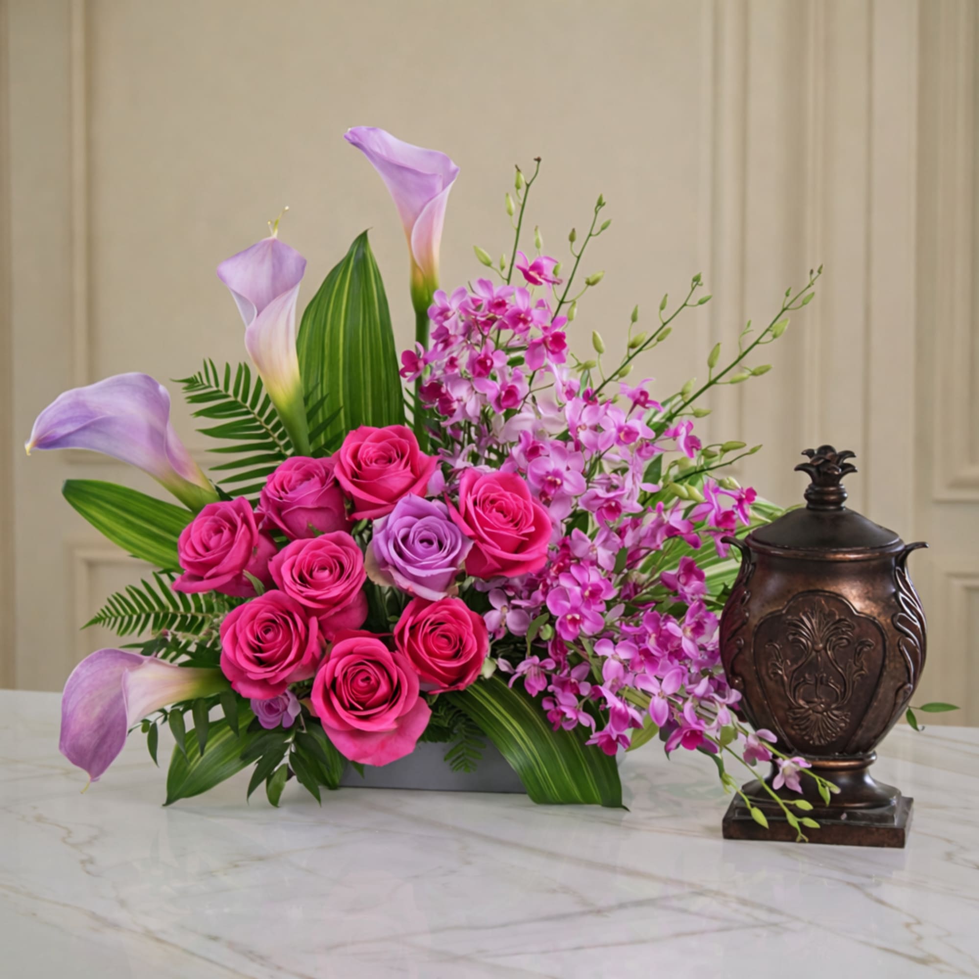 Pink roses and lavender calla lilies with purple orchids in a vase
