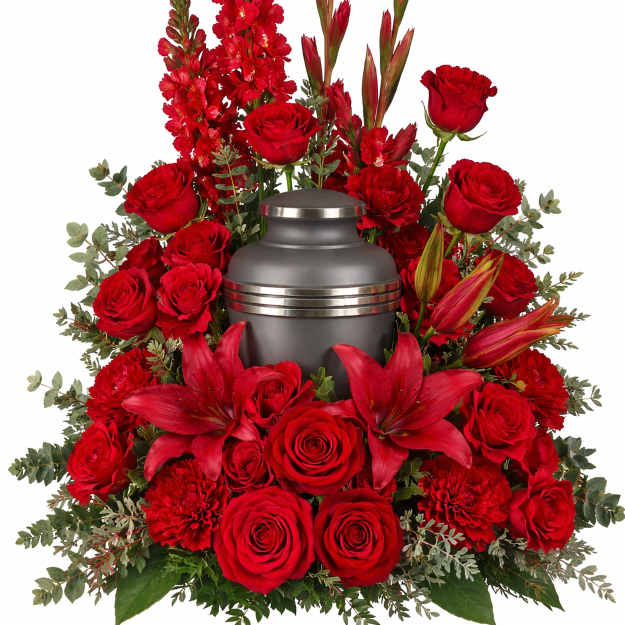 Red roses and lilies arranged around a gray urn