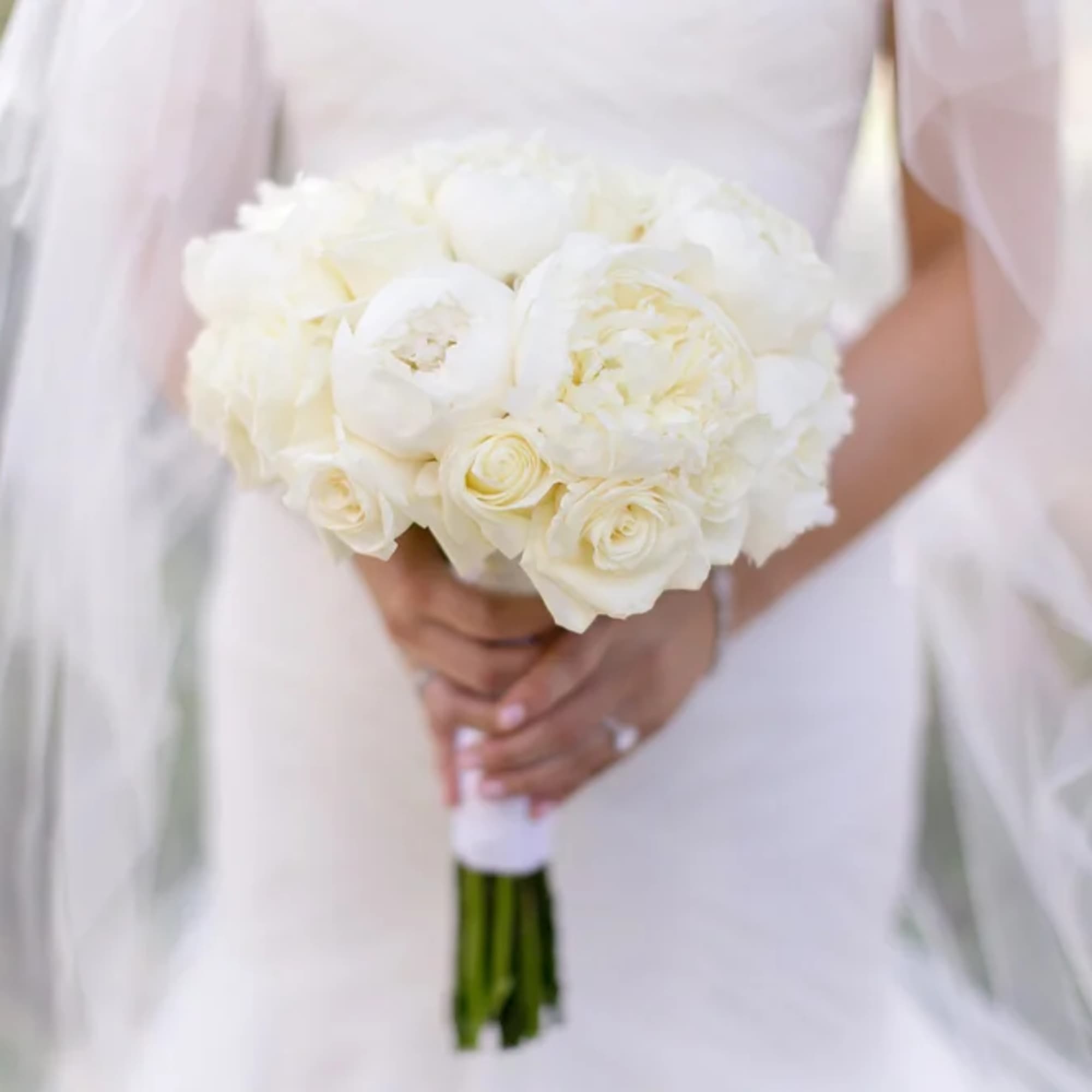 Bride holding a white rose and peony bouquet