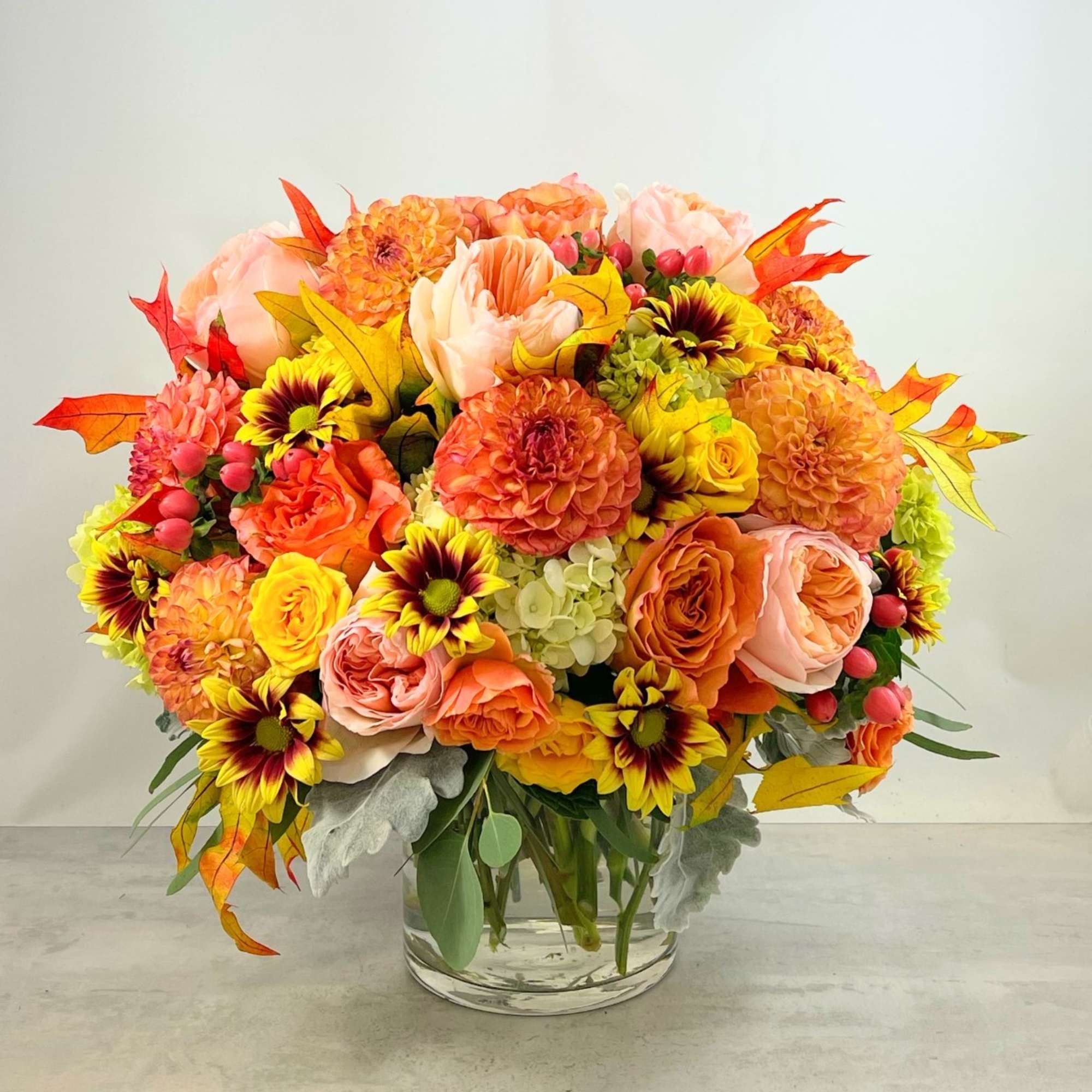 Amber leaves, yellow and bronze mums, dahlias glowing peach and orange roses