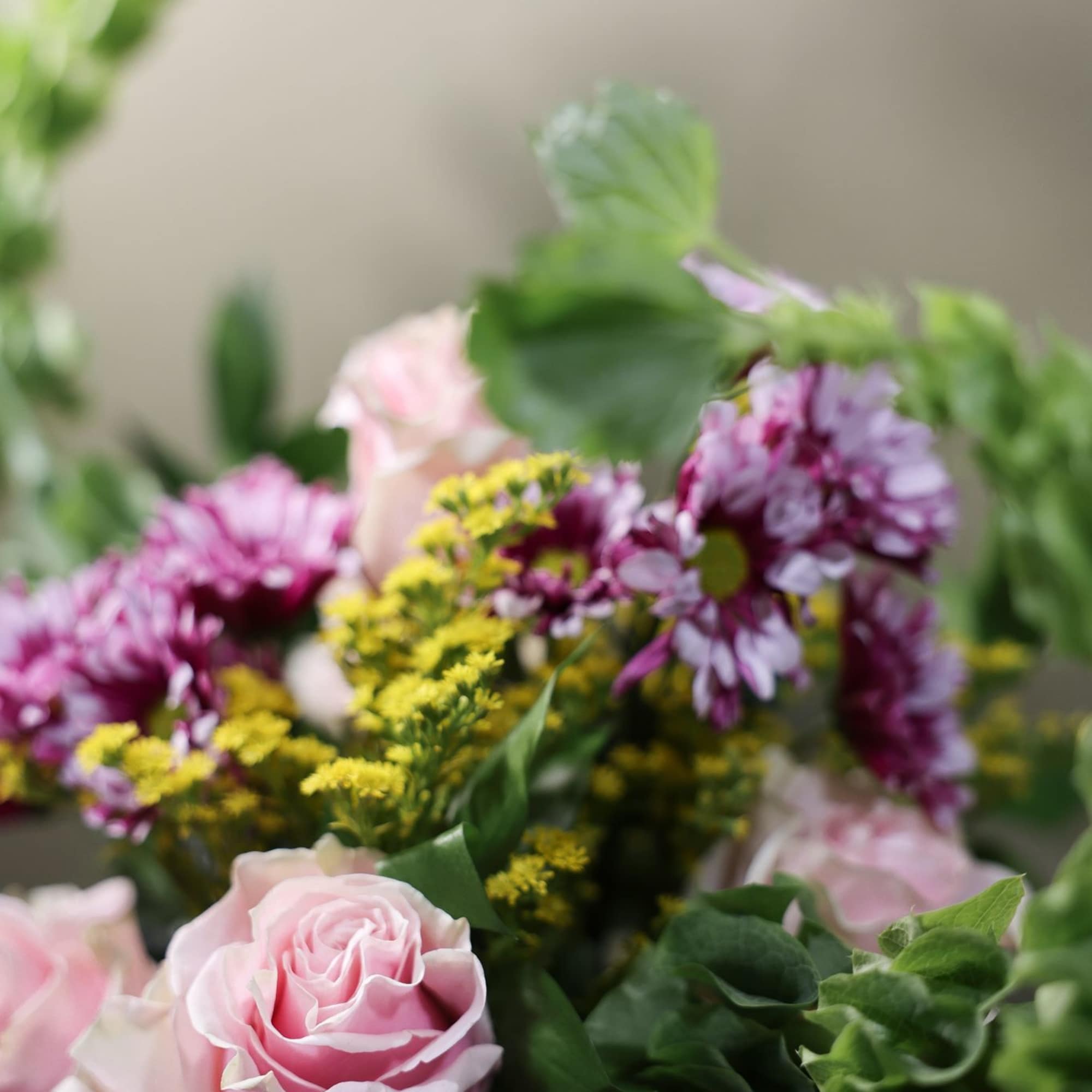 Pink roses and purple daisies with yellow filler flowers