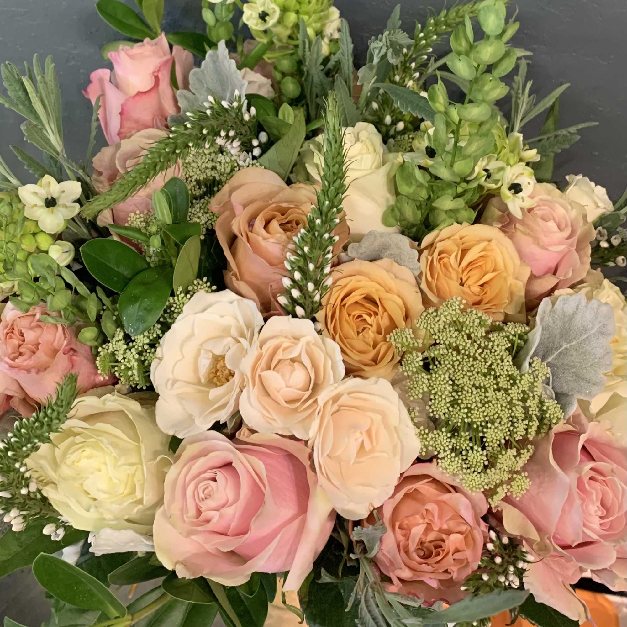 Bouquet of pastel roses with green filler flowers and foliage