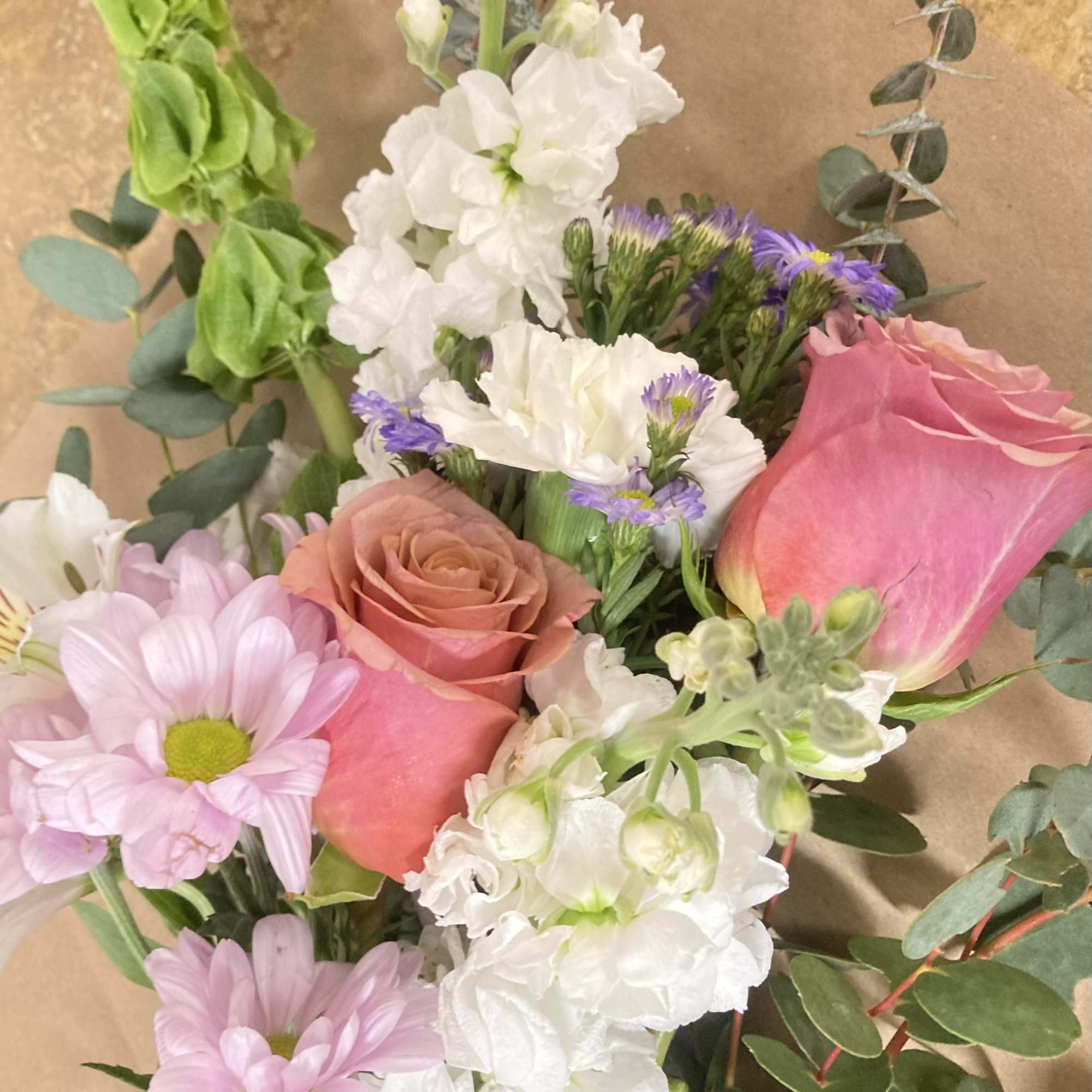 Mixed bouquet with pink roses, white blooms, and lavender daisies