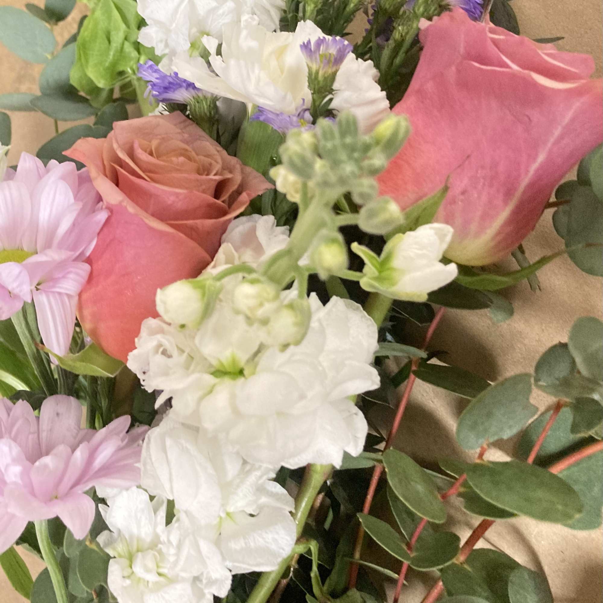 Mixed bouquet with pink roses, white blooms, and purple daisies