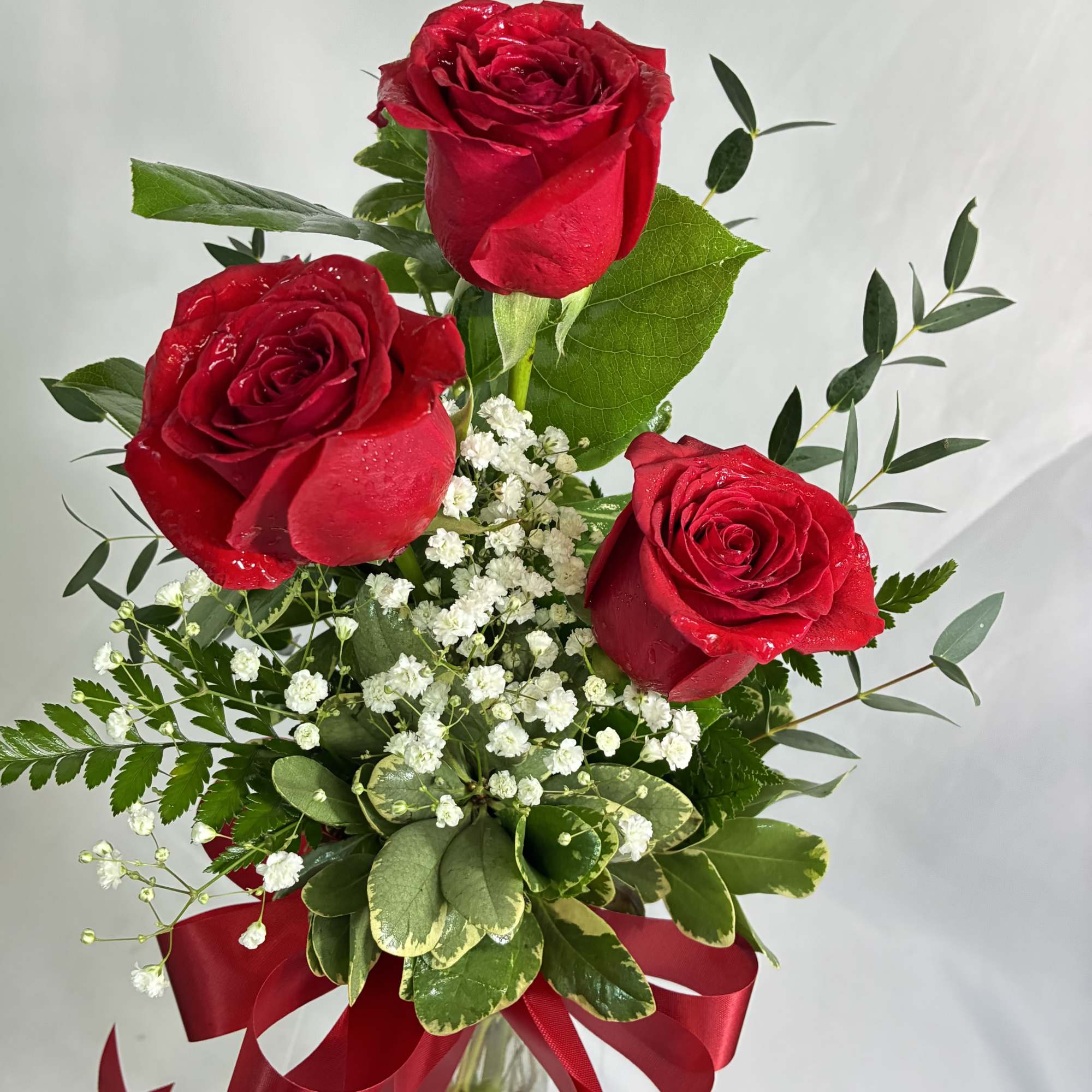 Bouquet of red roses with baby's breath in a glass vase