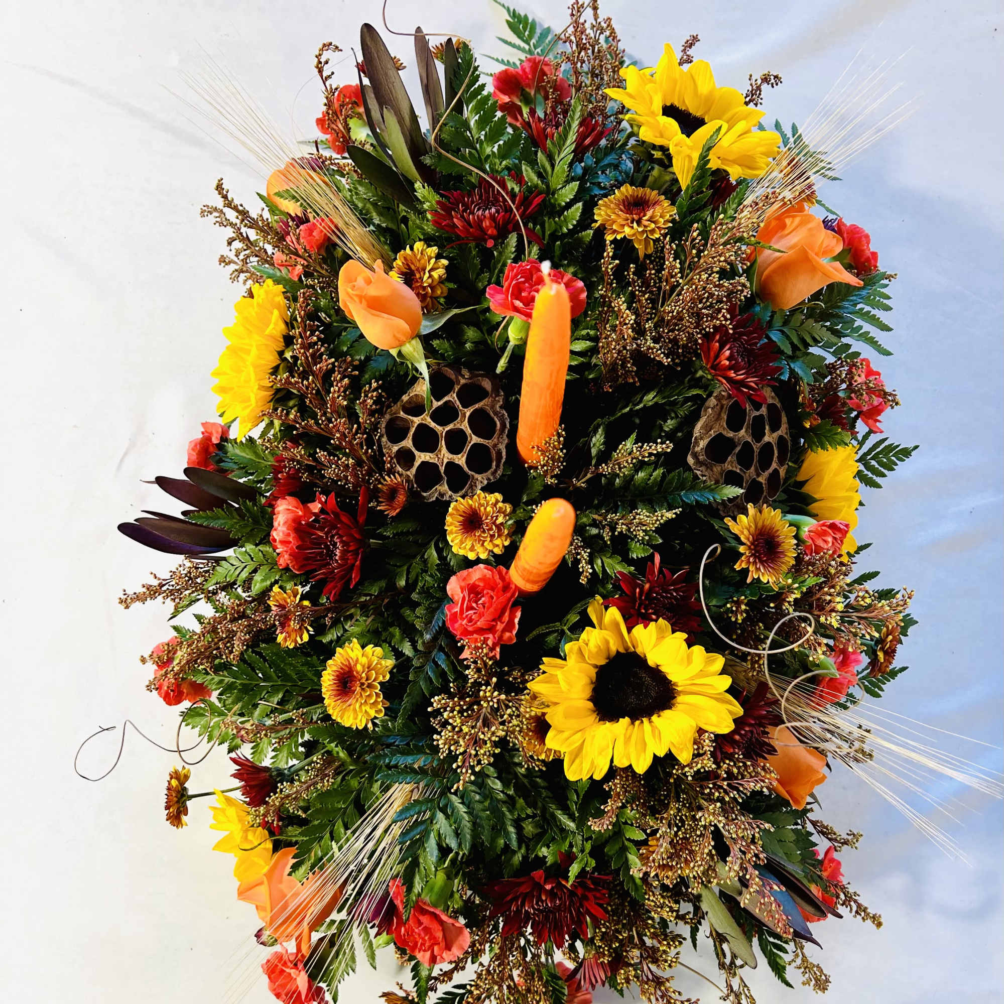 Colorful floral arrangement with sunflowers, orange roses, and red blooms