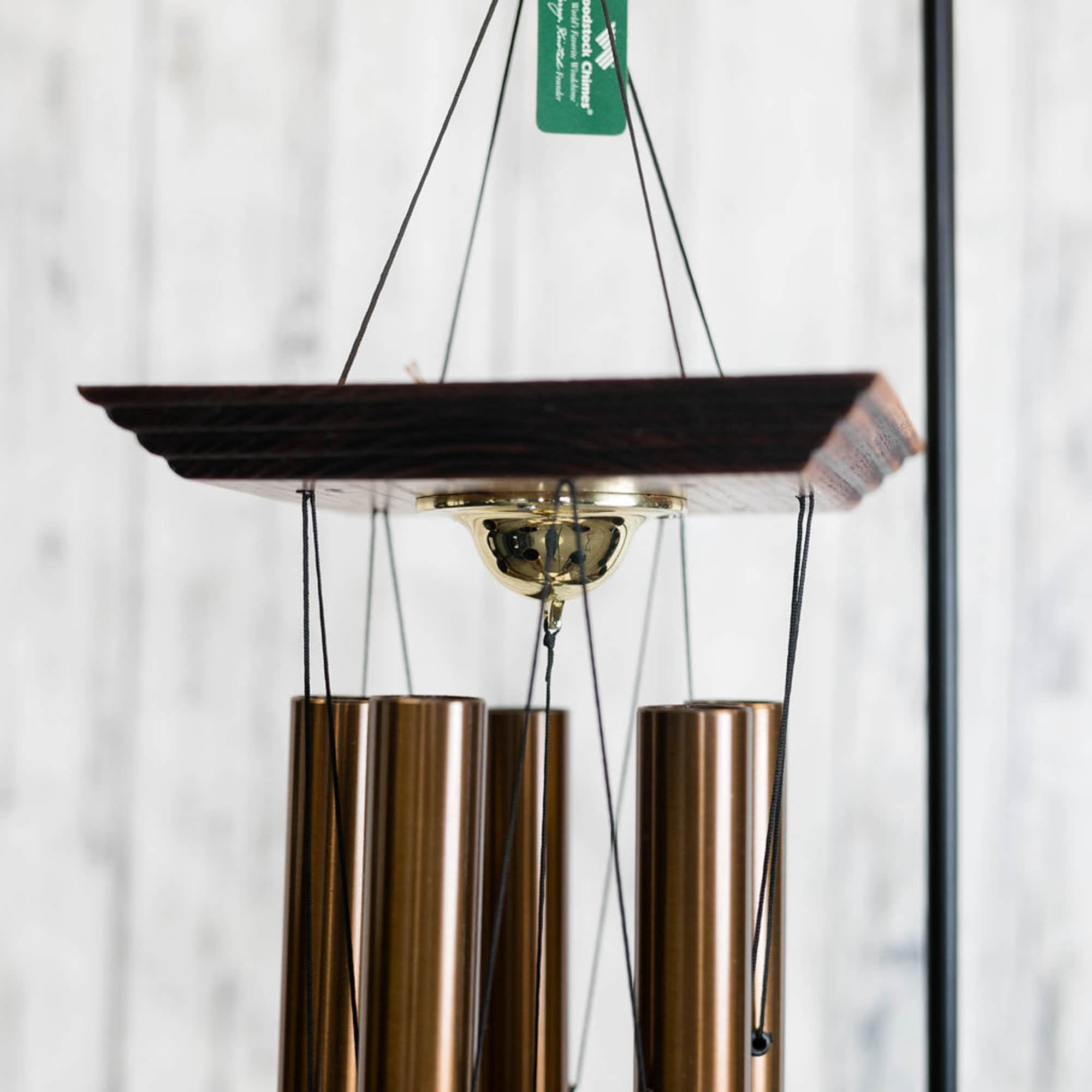 Hanging wind chime with bronze tubes and a dark wooden top