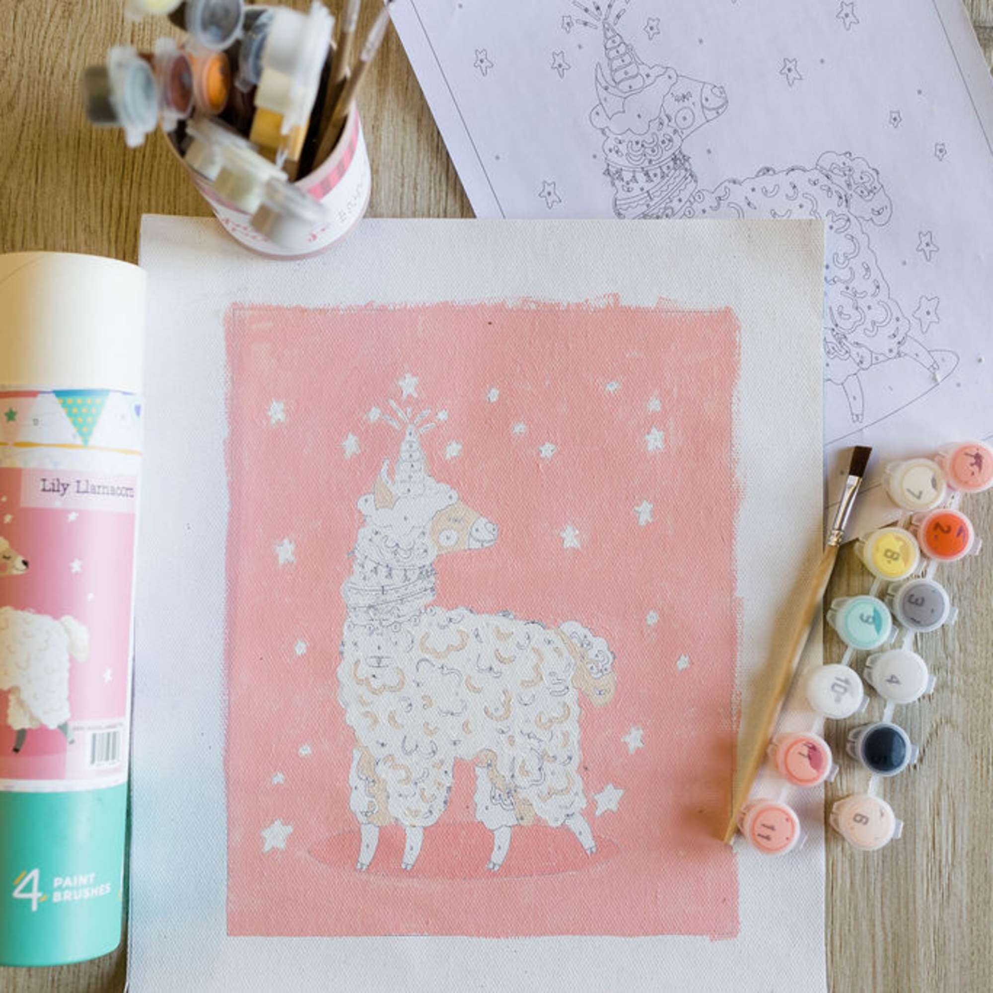 Paint-by-number art supplies with a llama painting on paper