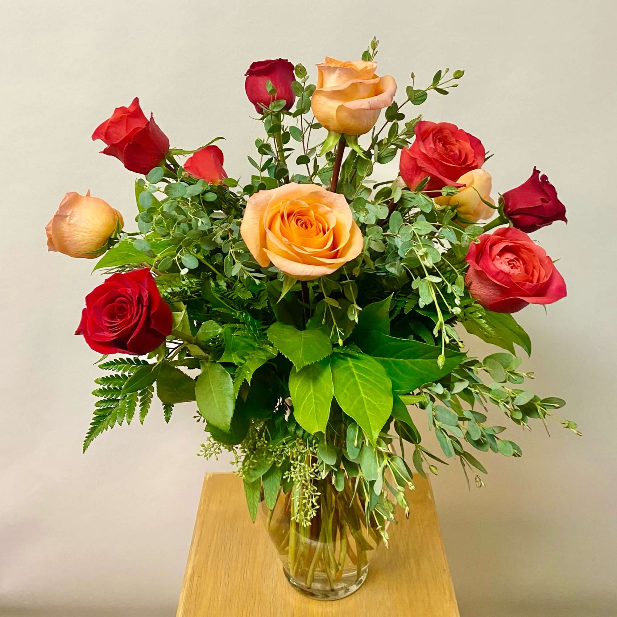 Bouquet of red and peach roses in a clear glass vase, photo 2 of 2