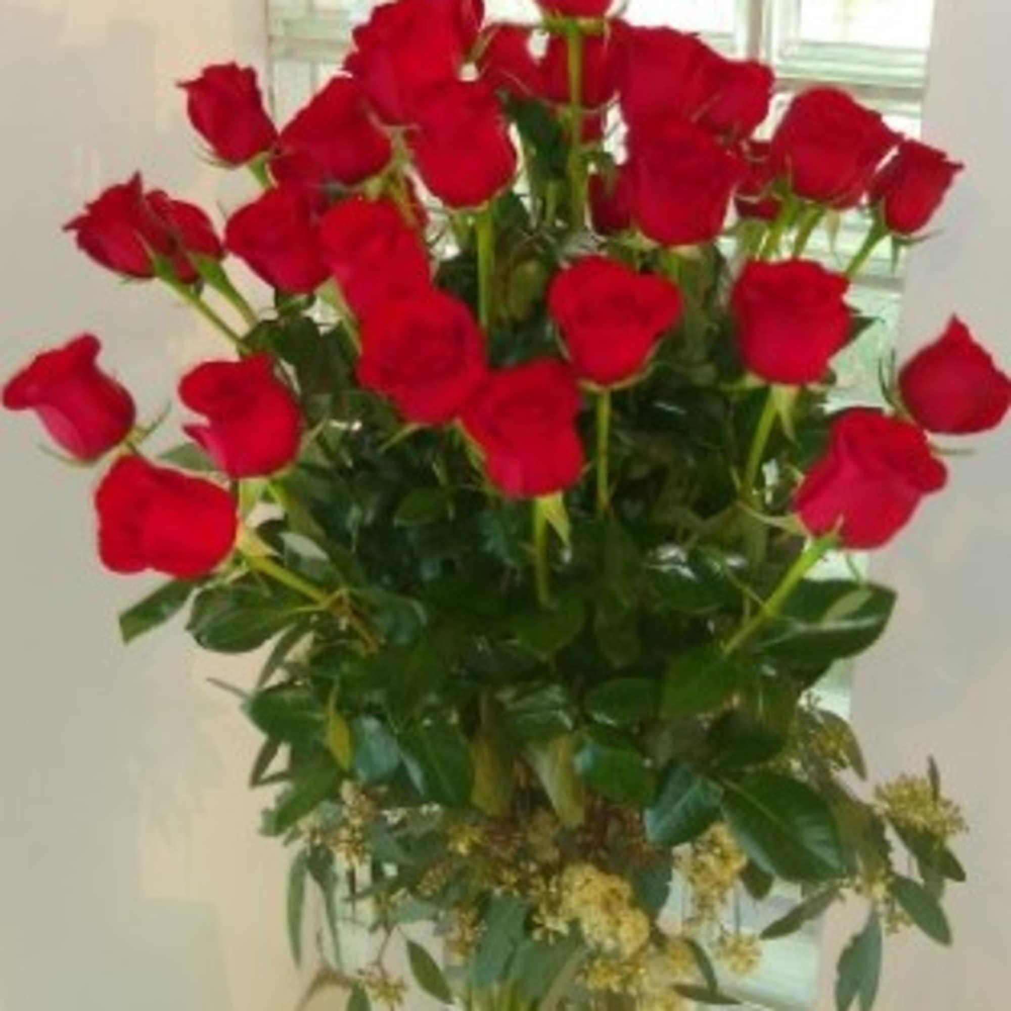 Tall bouquet of red roses in a glass vase
