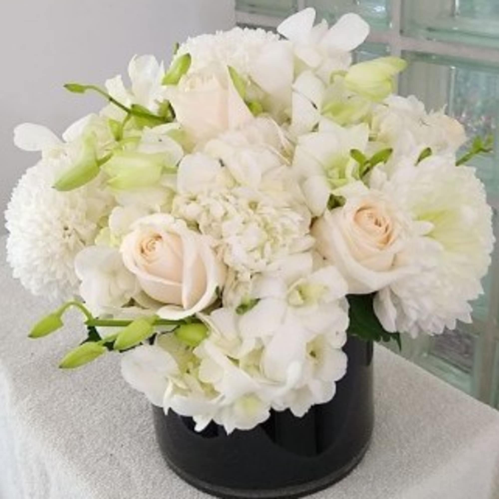 A plush cluster of mostly white blooms-big hydrangea heads cushioned by creamy