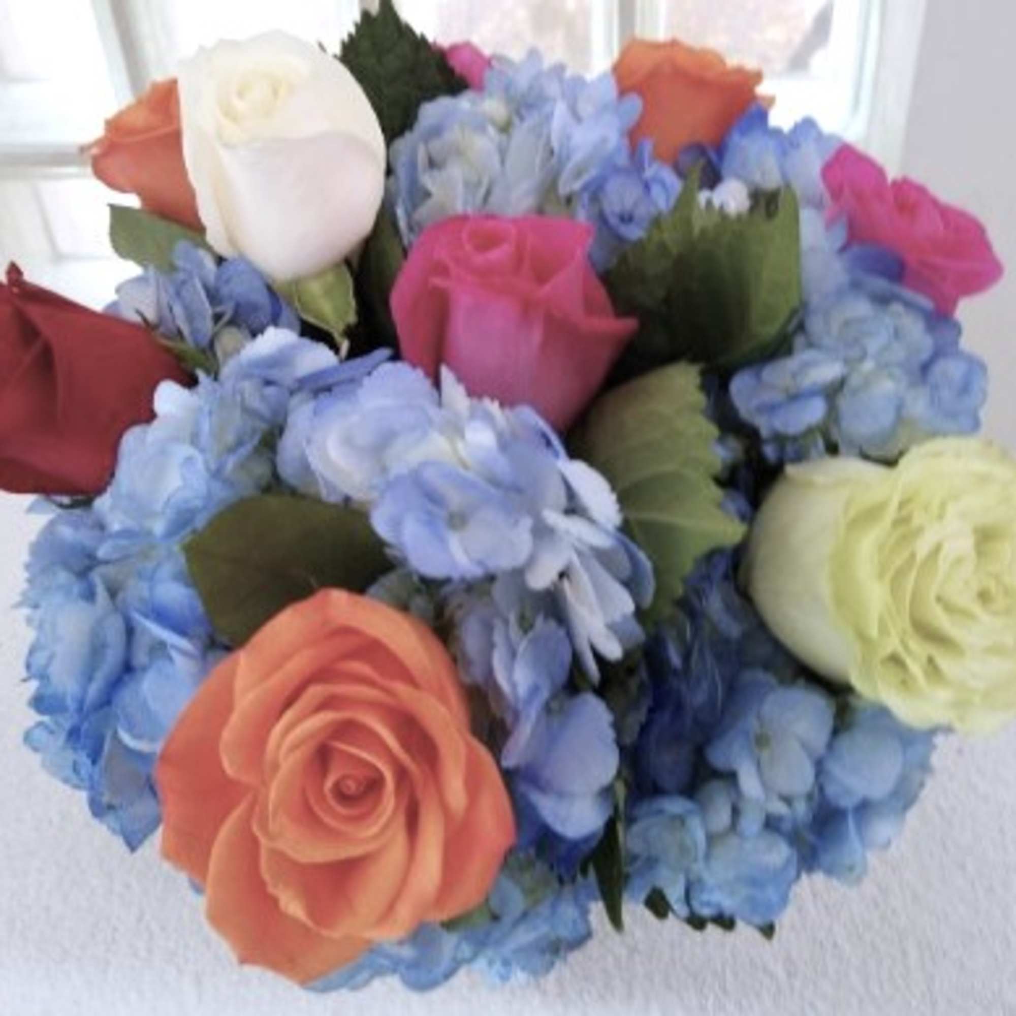 A cute showstopper. Bright multicolored roses make this darling arrangement pop. Perfect