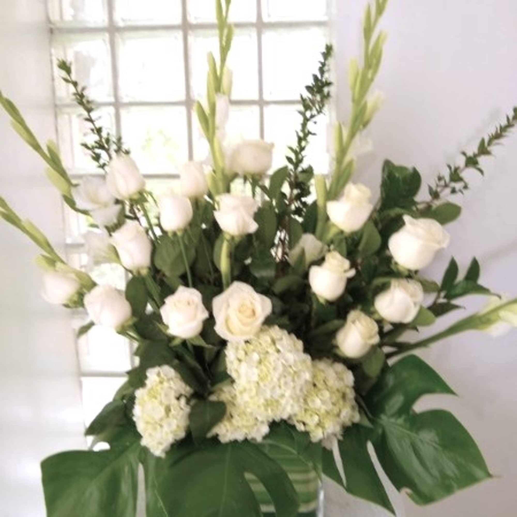 An all white tribute, this funeral basket is pure and tranquil. Featuring