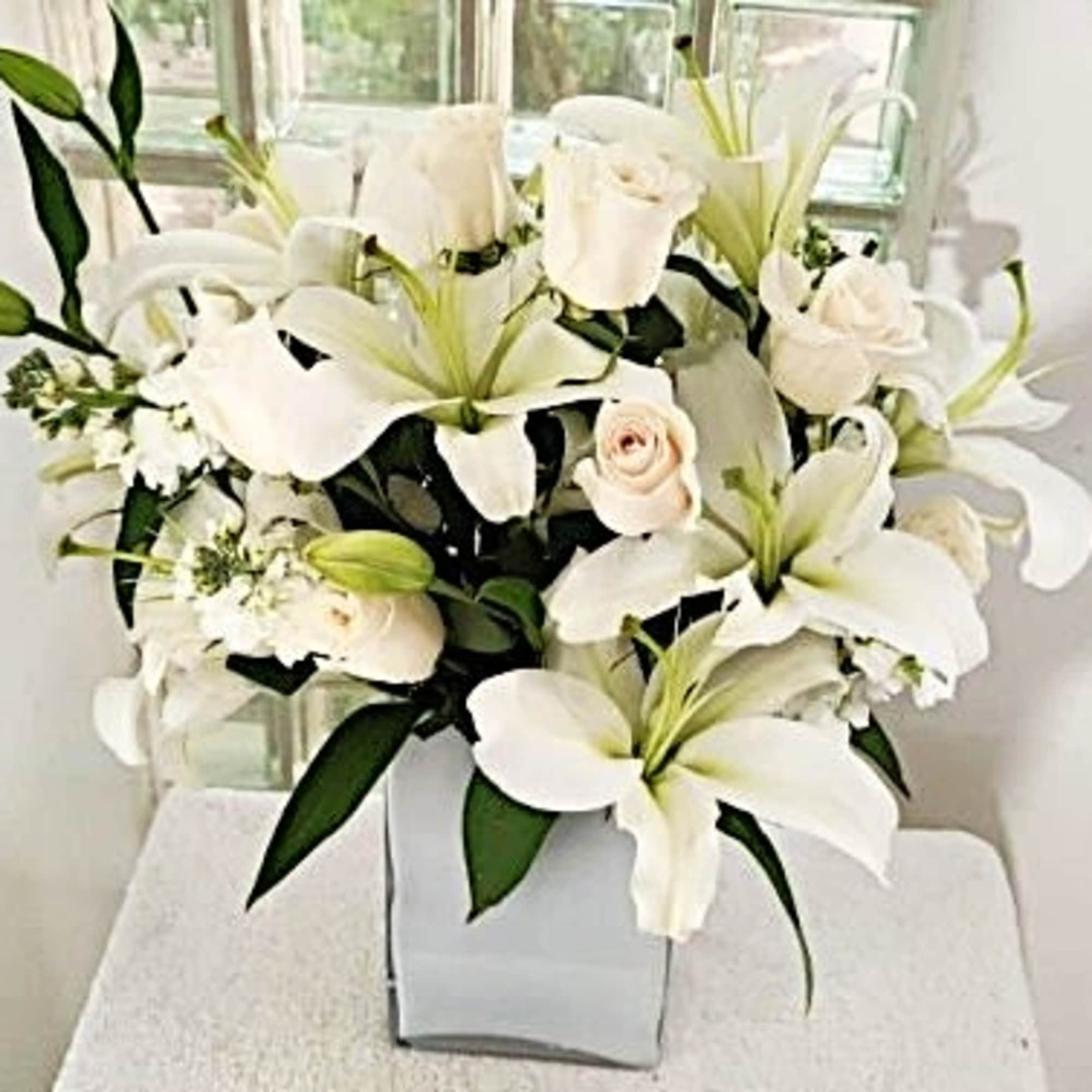 An all white combination of lilies, roses and snapdragons.